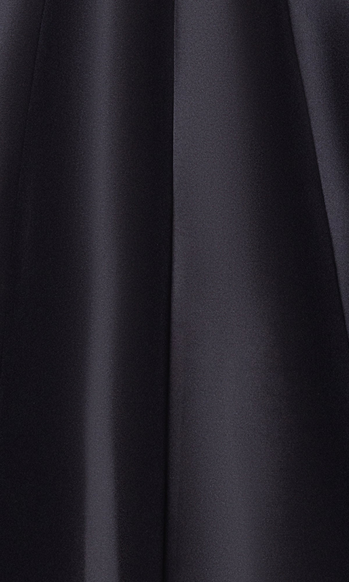 Close-up of smooth, shiny black fabric with gentle folds and soft light reflections, reminiscent of the elegant Tea-Length Black Formal Dress: Betsy and Adam A27115.