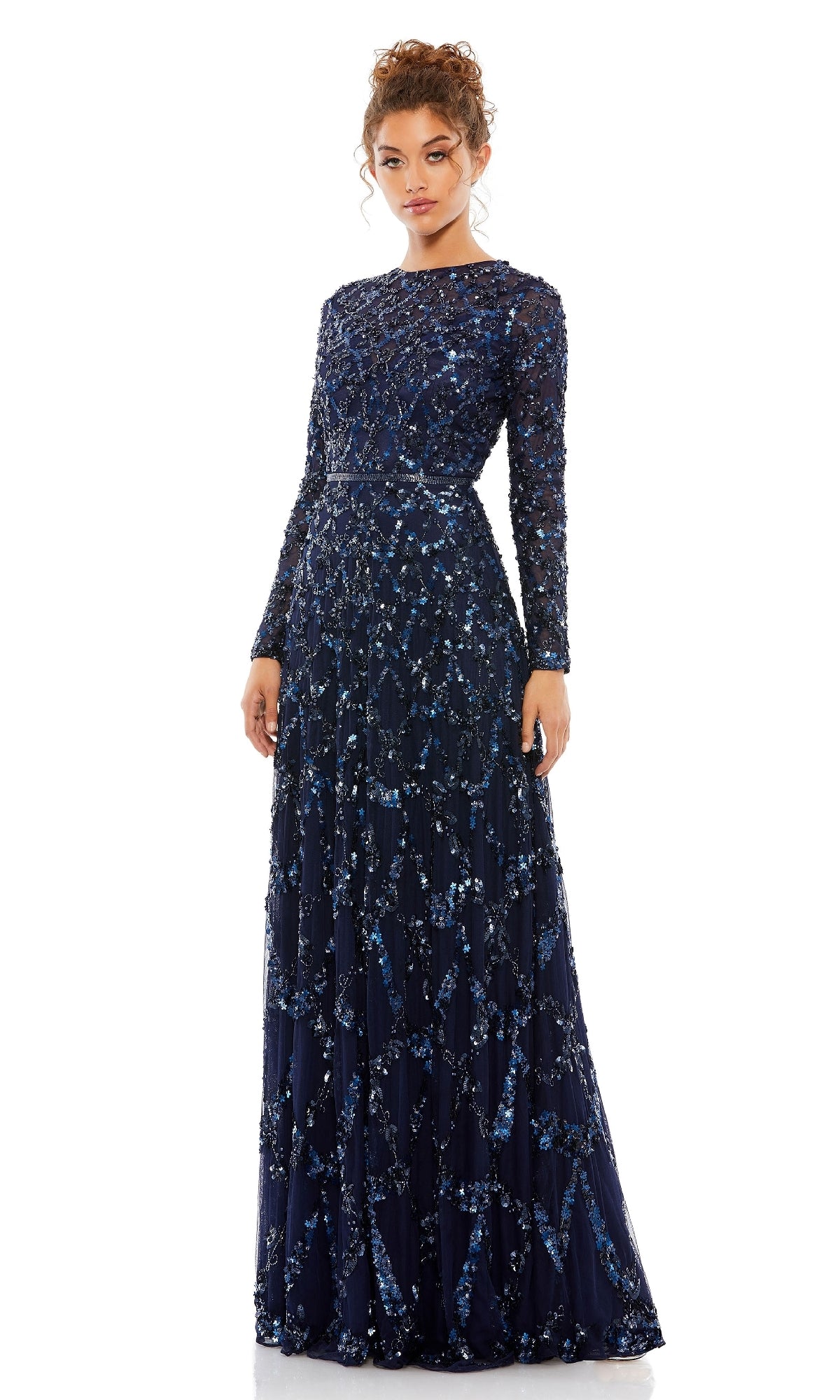 A woman models the Mac Duggal 5496 Long Sleeve Sequin Formal Gown in navy blue, featuring sparkling sequins and beading—a stunning choice for special occasions—against a plain white background.