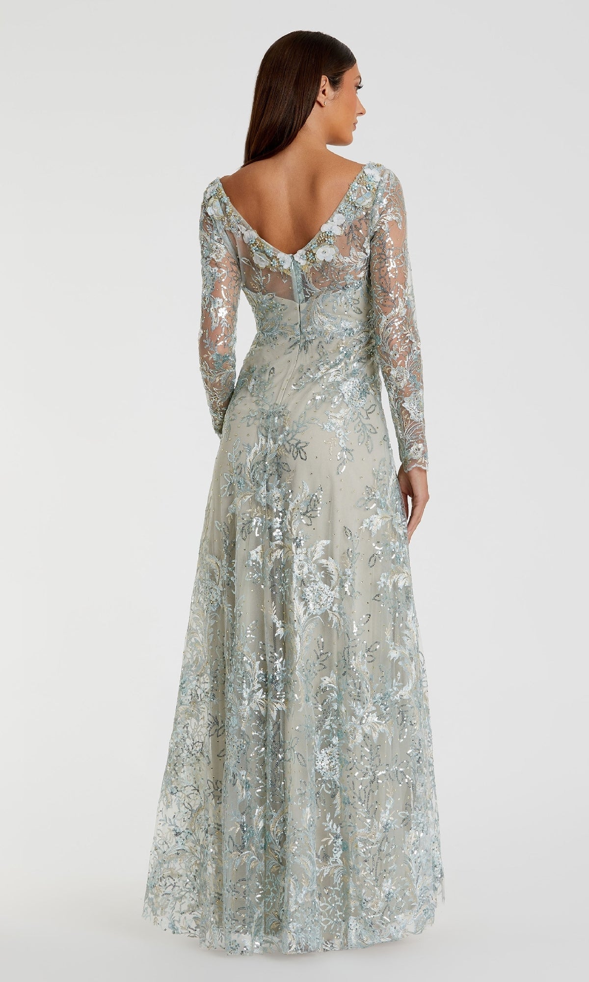 A woman faces away, wearing the Mac Duggal 67498 long sleeve formal dress in light blue lace, featuring sheer sleeves and a V-back design.