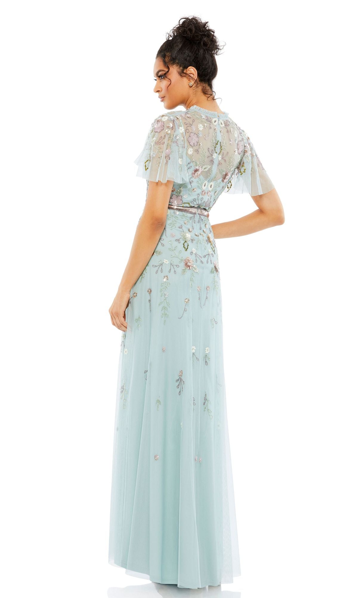 A woman faces away, wearing the Long Formal Dress 9136 by Mac Duggal—a light blue beaded A-line gown with short sheer sleeves and delicate floral embroidery.