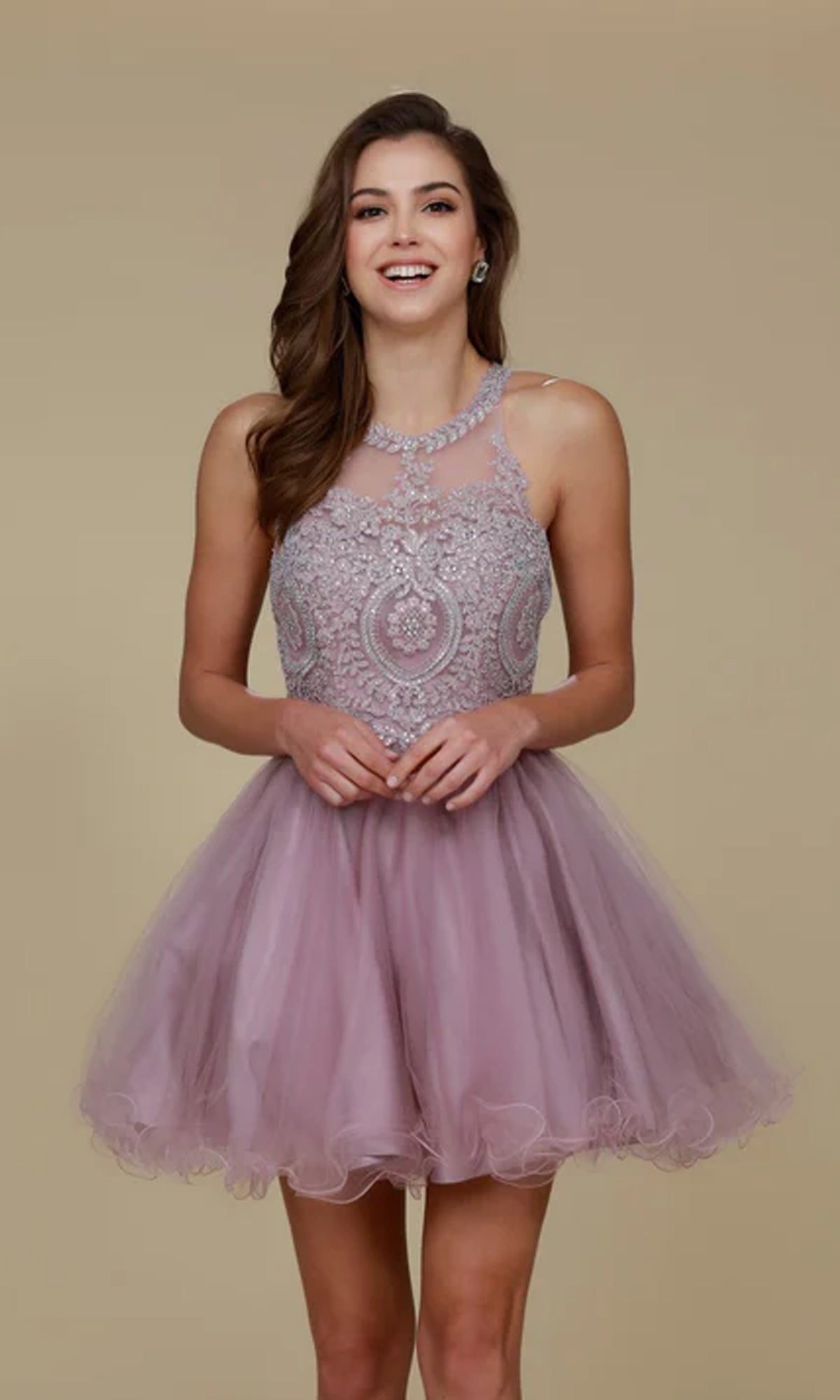 A woman smiles at the camera, wearing the Short Babydoll Homecoming Dress with Beading—sleeveless, lilac, a-line style featuring intricate beadwork on the bodice—standing against a plain beige background.