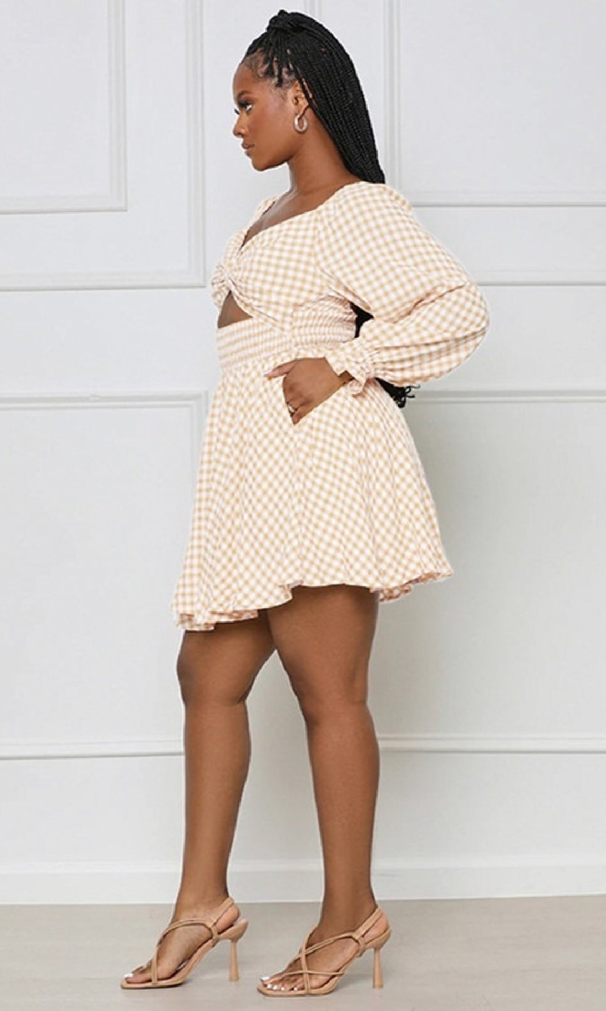 Woman in profile wearing the Long-Sleeve Short Casual Gingham Print Dress in light beige and white, styled as a crop top and matching skirt, paired with beige heels.