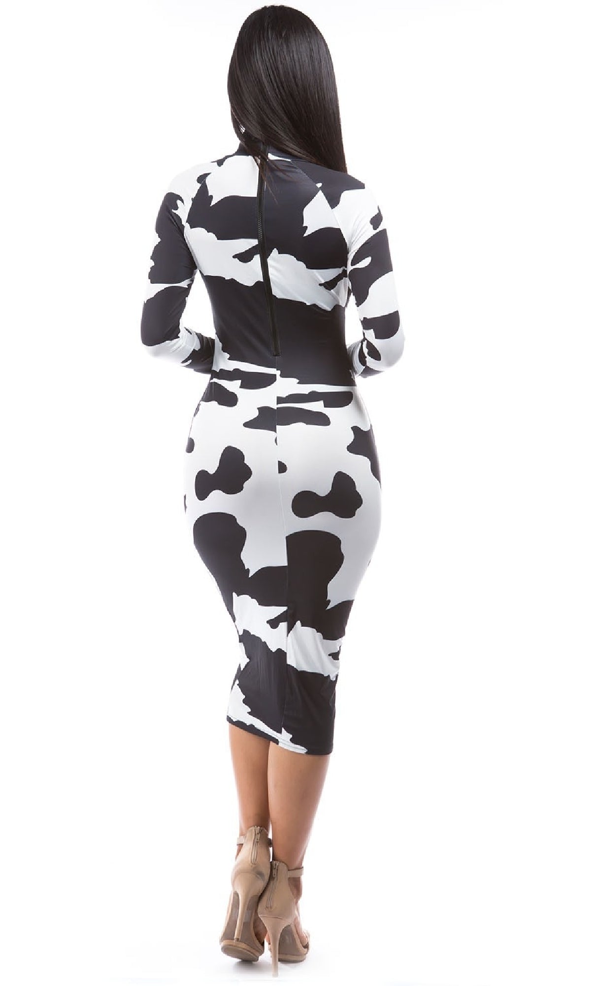 A woman faces away, wearing the Long Sleeve Cow Print Bodycon Midi Dress with a front zipper neckline and beige high heels, set against a white background.
