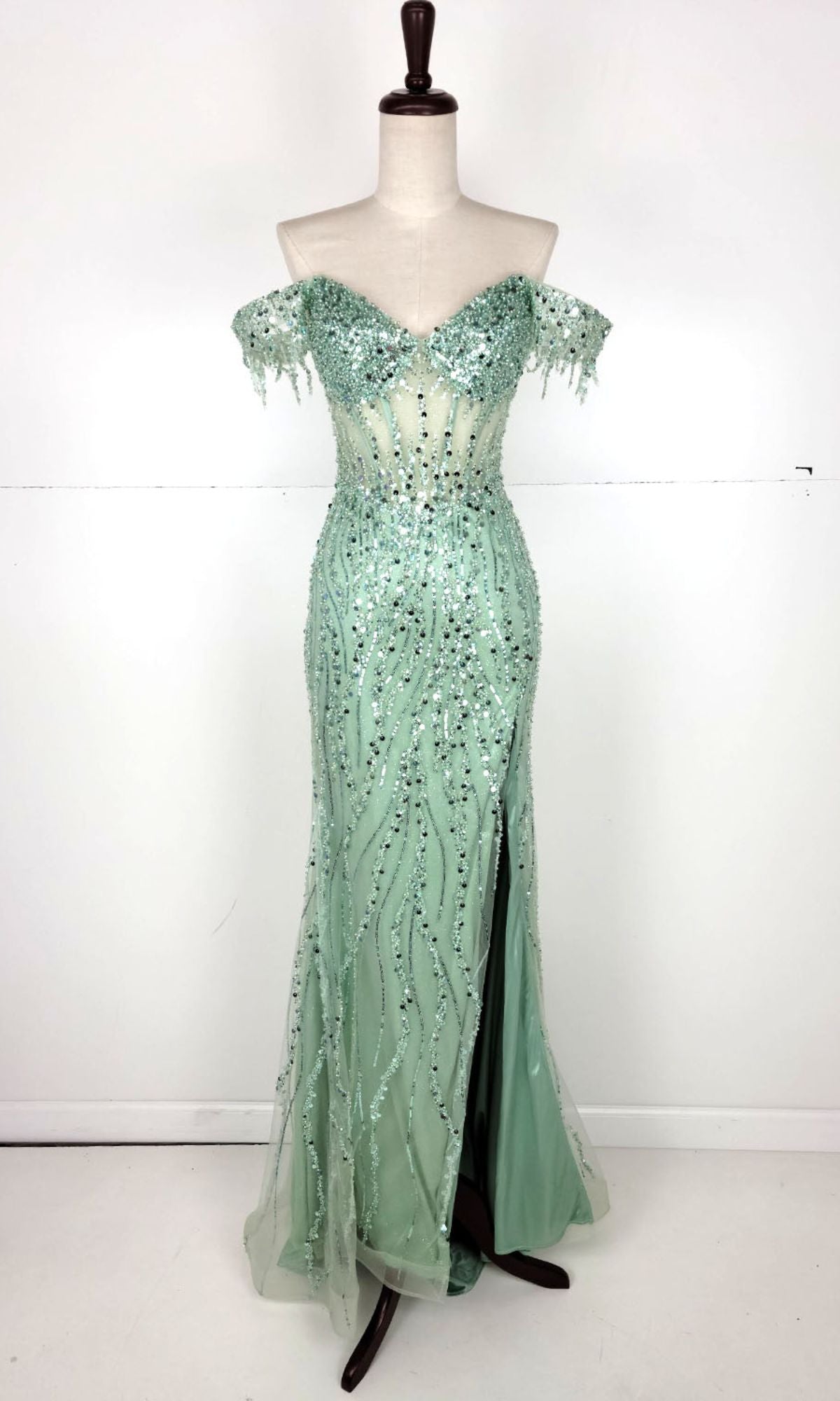 The Chicas C331 Off-Shoulder Long Sequin Prom Dress in mint green features a sweetheart neckline, high slit, and floor-length skirt—an ideal choice for your next formal event.