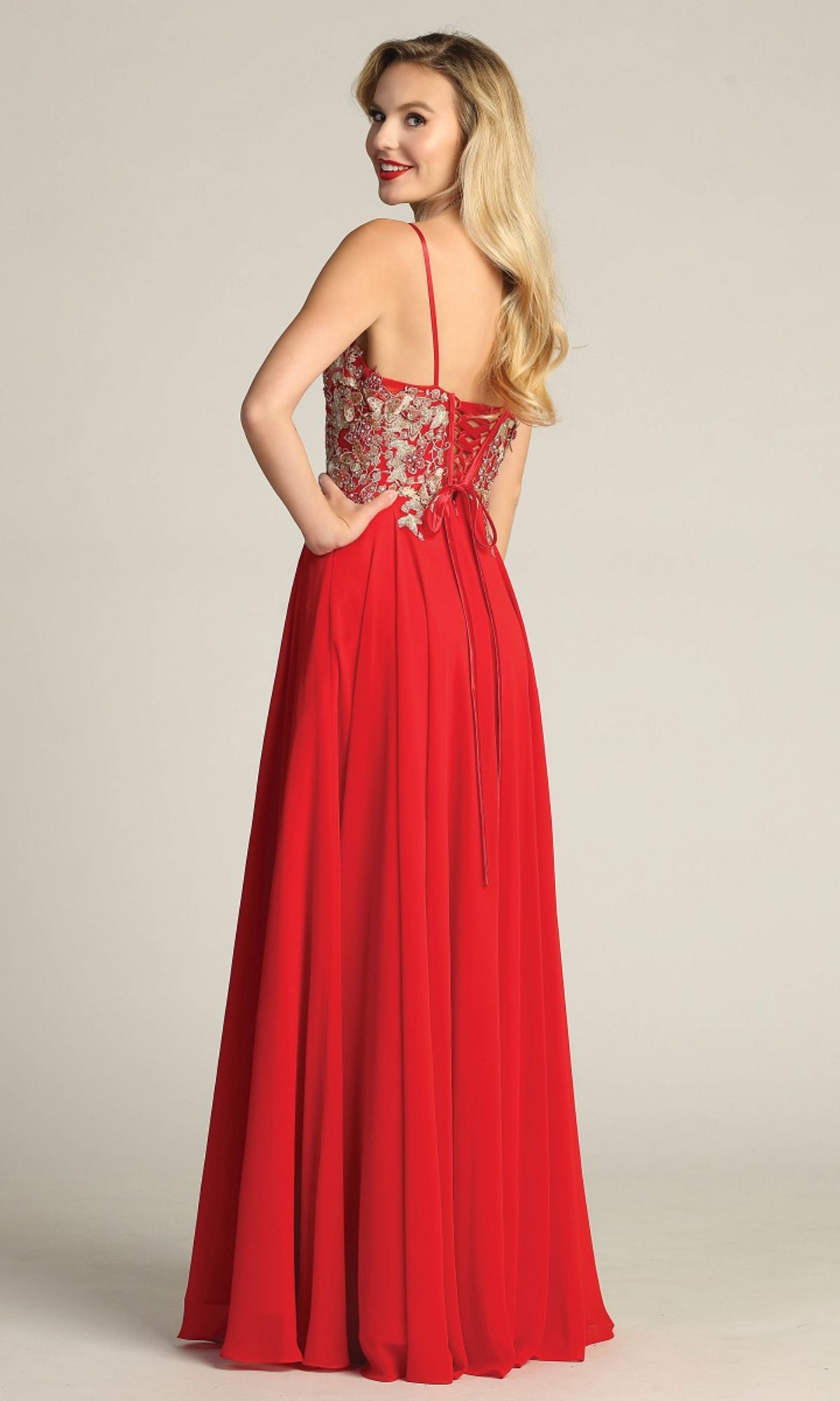 Woman models the Lace-Up Open-Back Long Prom Dress: Chicas C5124, showing off its elegant A-line silhouette and floral-embroidered bodice while posing with her back turned and hands in the pockets.