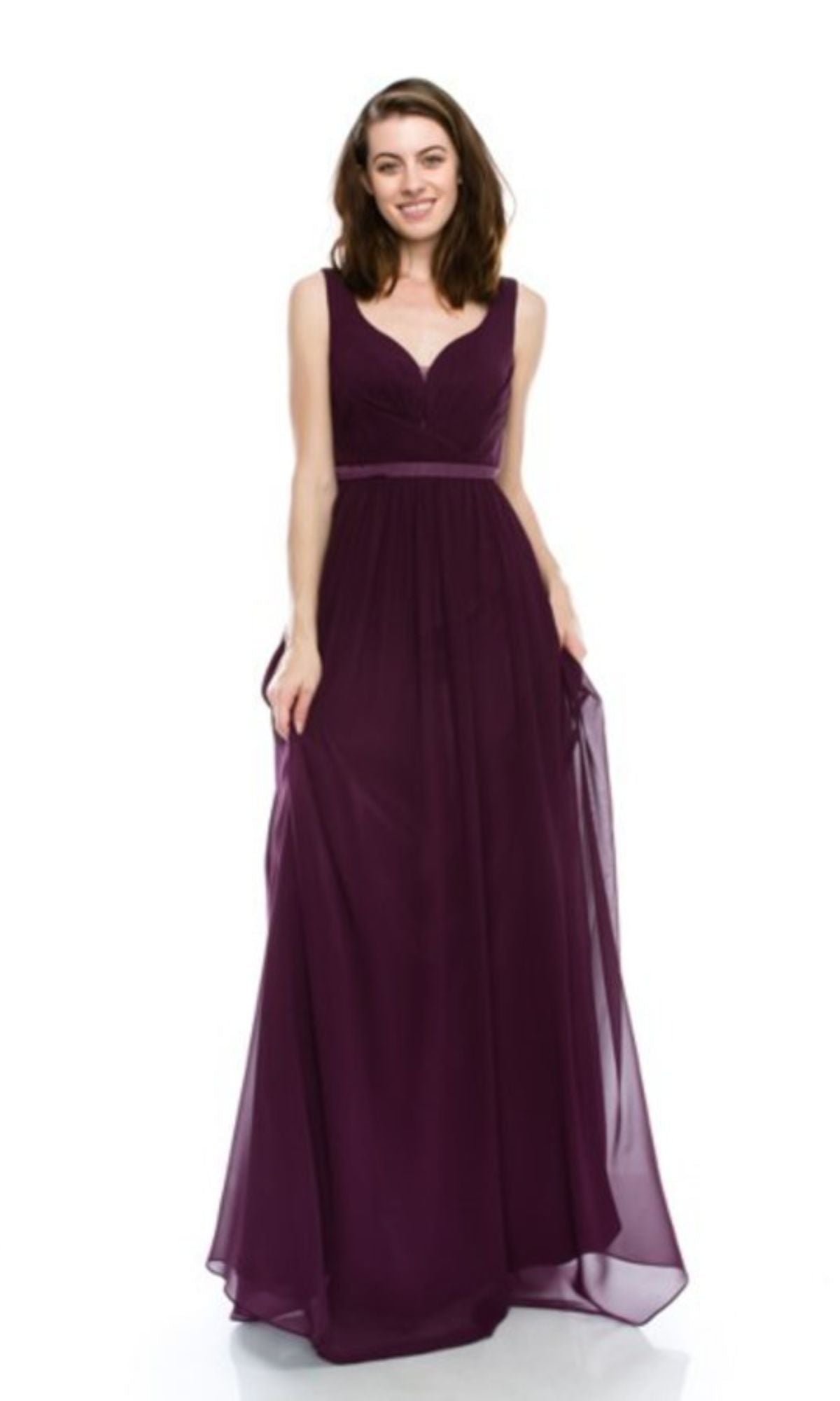 A woman stands and smiles against a plain white background, modeling the Chicas C7818 Deep V-Back Long A-Line Prom Dress in deep purple.