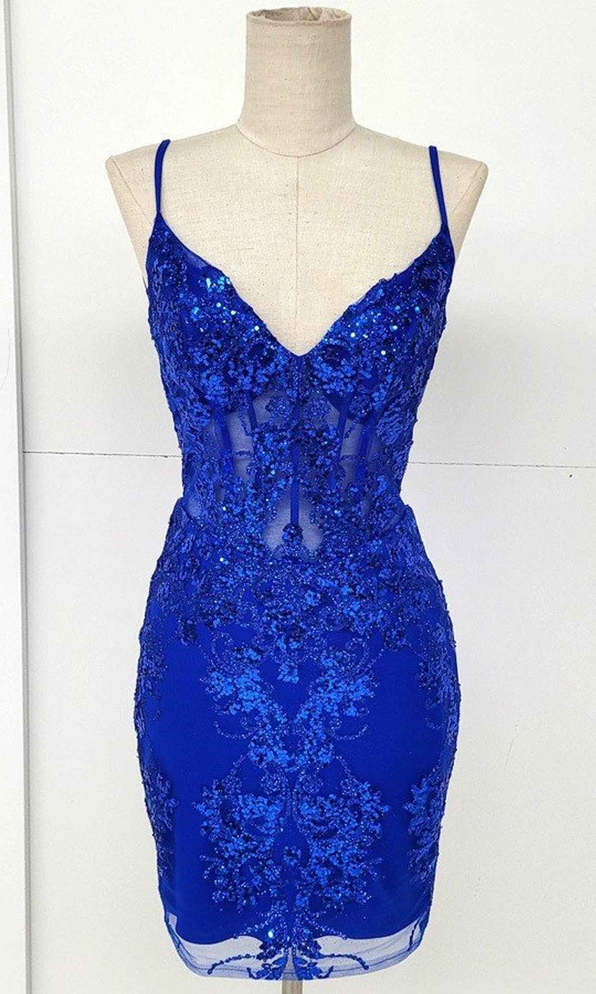 A mannequin showcases the Sheer-Corset Short Glitter Homecoming Dress C814, featuring a fitted sleeveless blue design with thin straps, sequin details, and sheer panel accents.