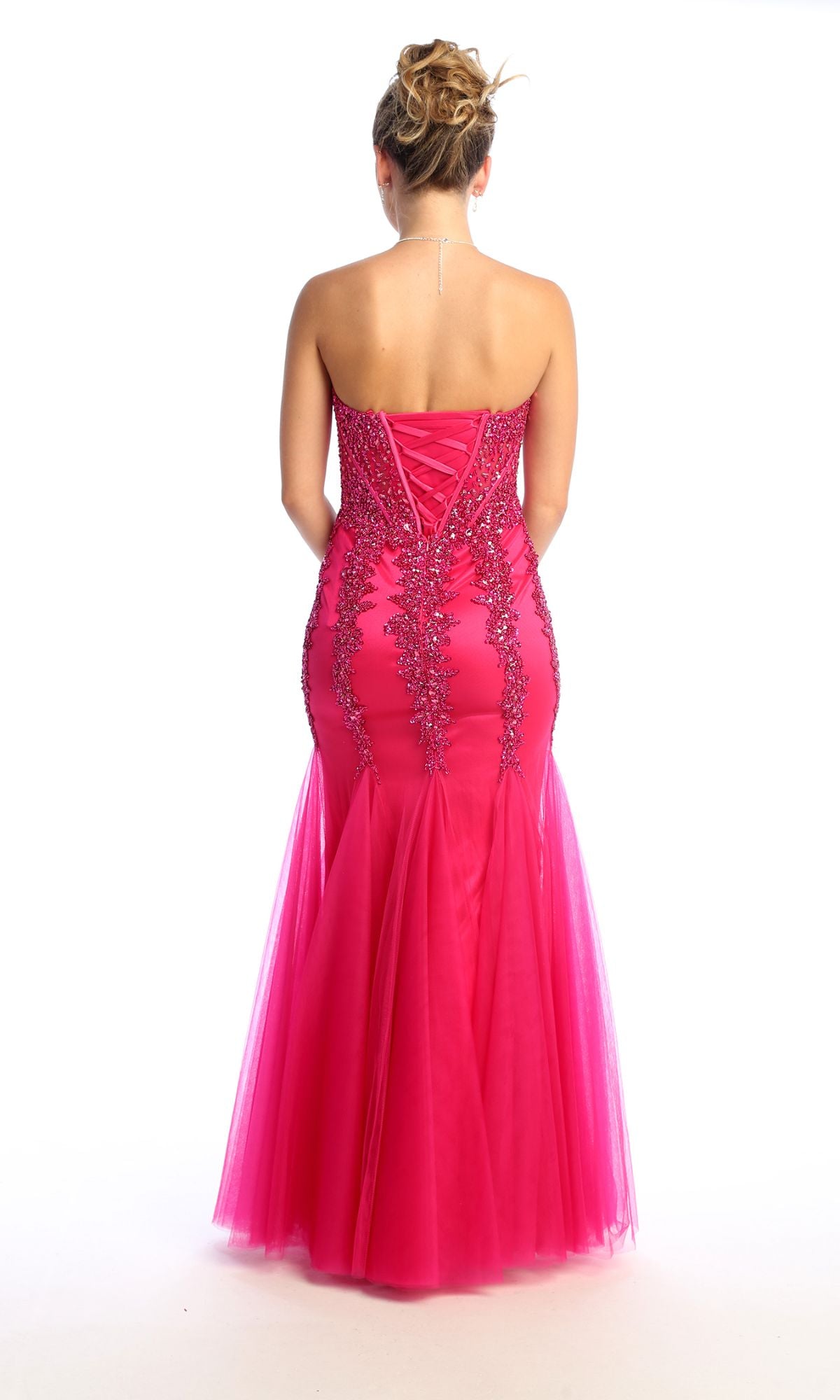 A woman faces away, wearing the Strapless Long Mermaid Prom Dress: Chicas C820 in hot pink, featuring beaded sequins, a lace-up back, and a mermaid silhouette.