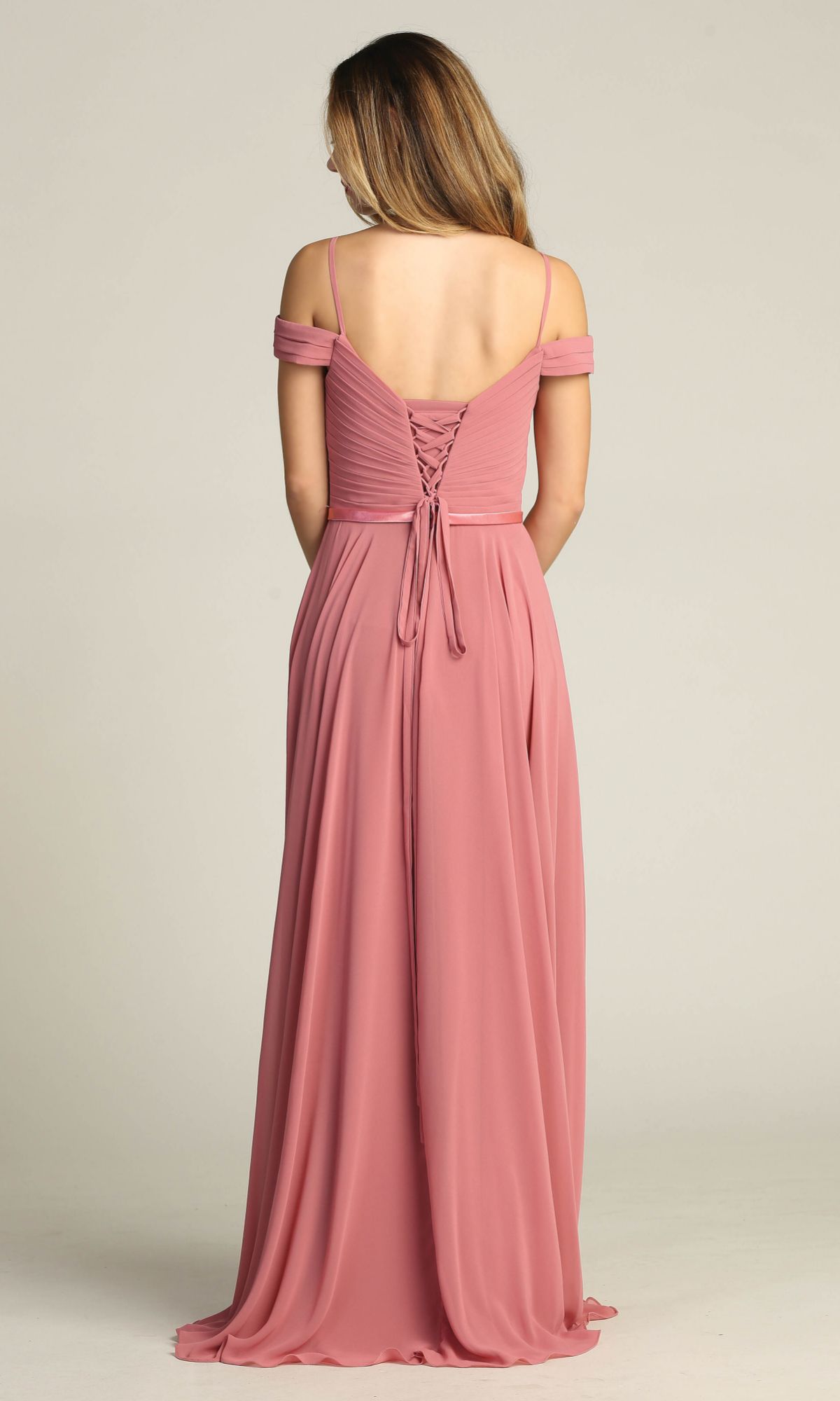 A woman faces away, wearing the Chicas C8997 Long A-Line Off-Shoulder Prom Dress in dusty pink, featuring off-the-shoulder straps and a delicate lace-up back.