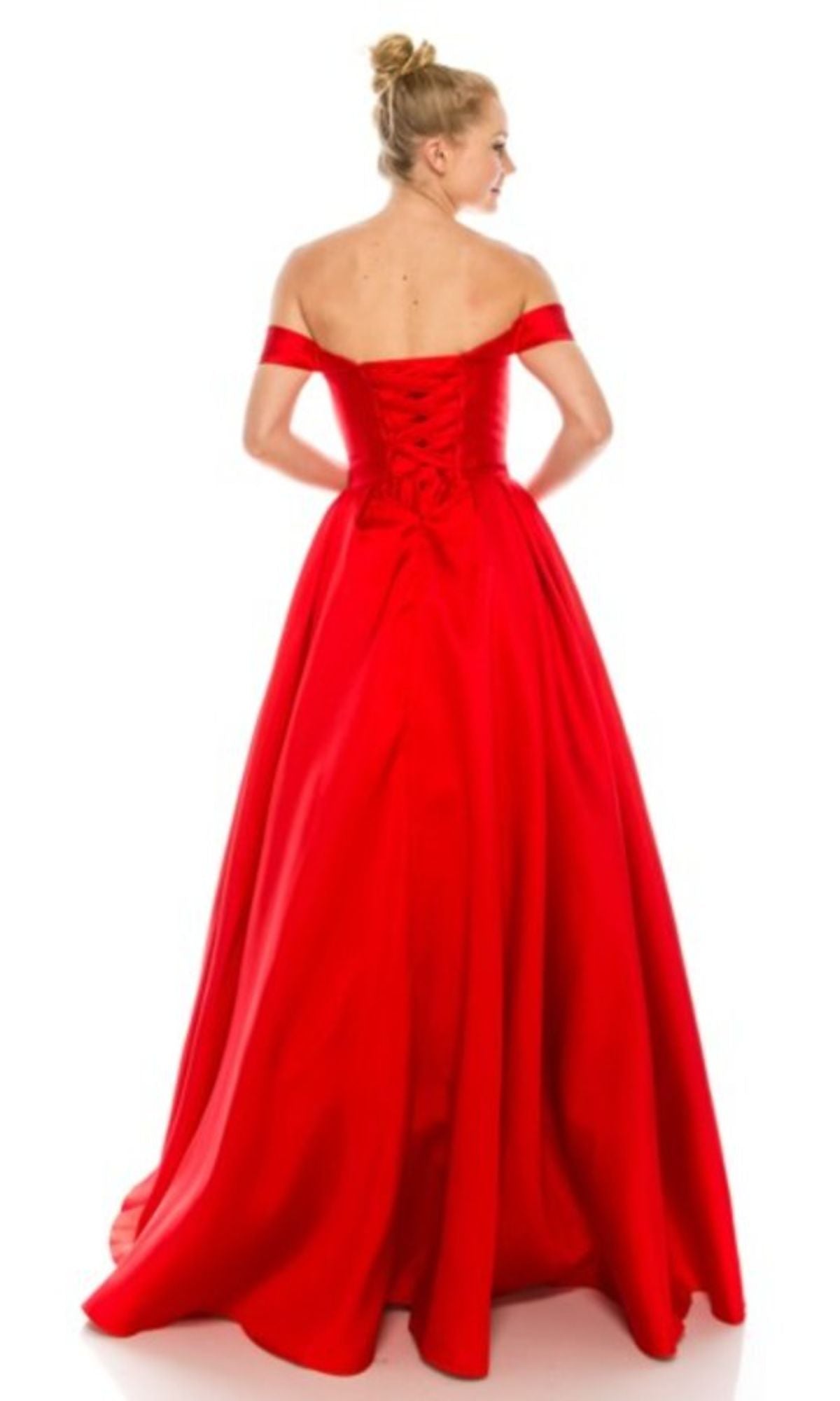 A woman wearing the Off-the-Shoulder Long Prom Ball Gown: Chicas C9197, a red, floor-length dress with a lace-up back, stands out against a white background as she faces away from the camera.