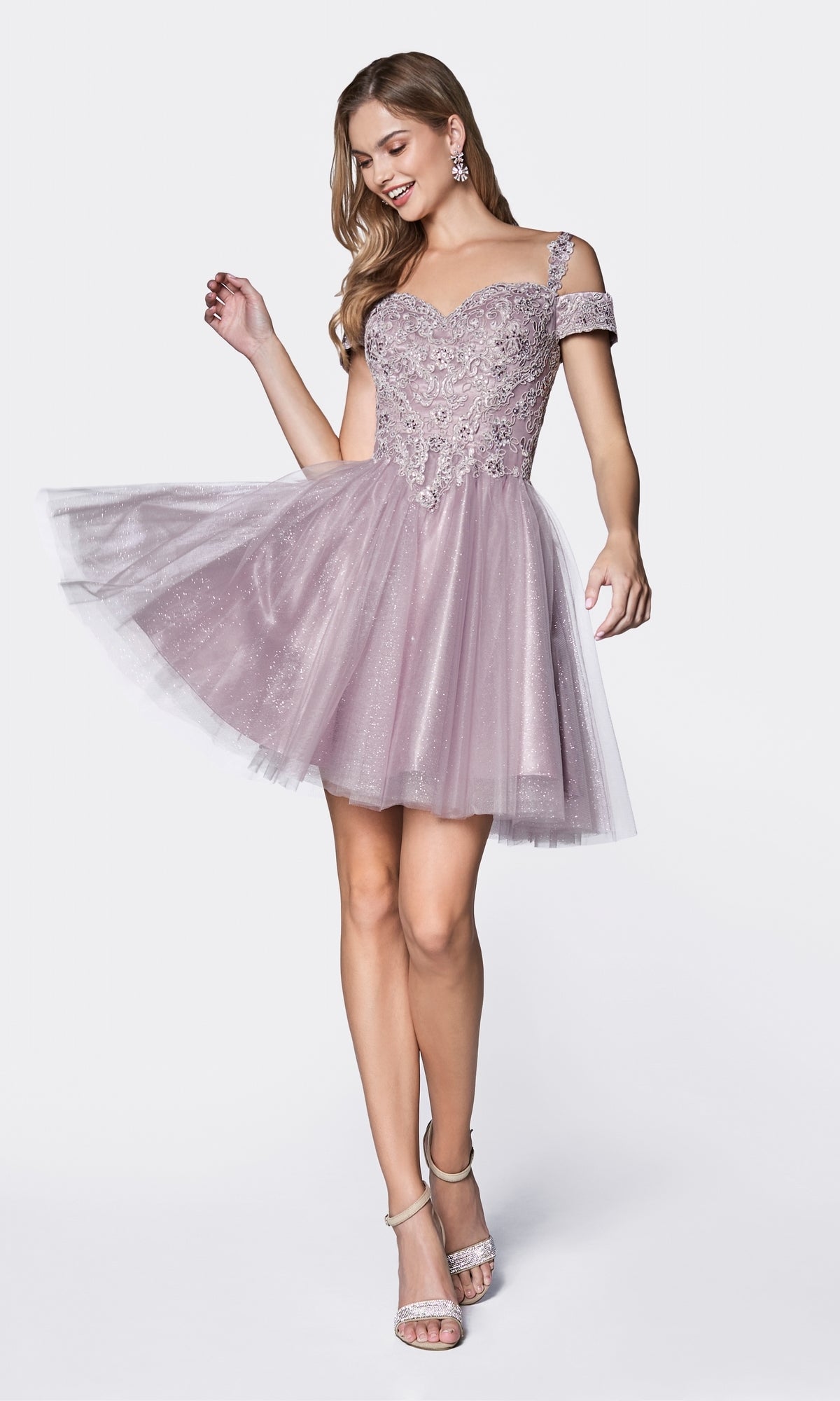 A woman poses elegantly in the Cold-Shoulder Short Glitter Homecoming Dress CD0132, featuring light purple fabric, floral embellishments, a tulle skirt, and cold-shoulder style against a plain white background.