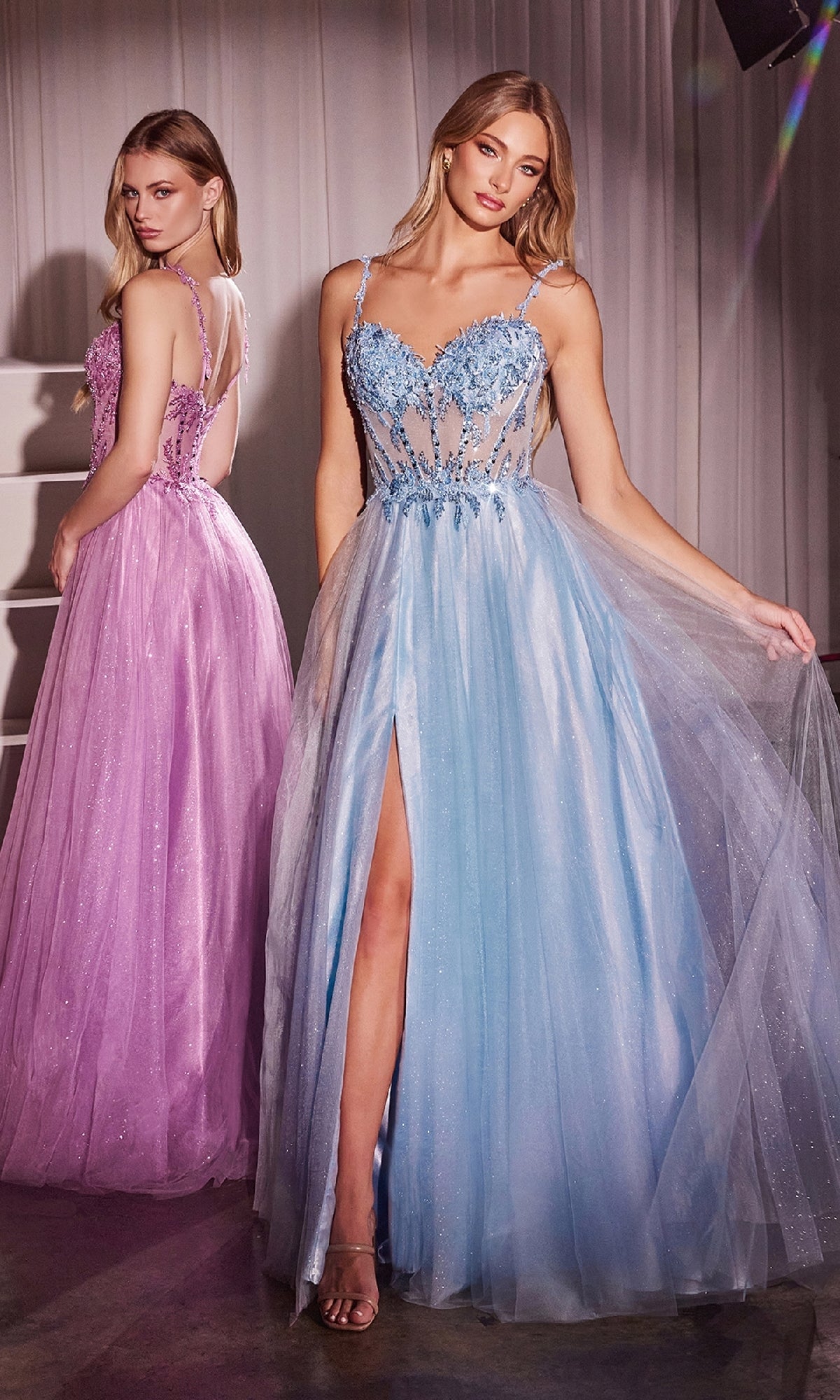Two women wear Ladivine CD0234 Glitter-Tulle Long Prom Dresses—one in lavender with an embellished sweetheart bodice, the other in light blue—posing in a softly lit room with sheer white curtains.