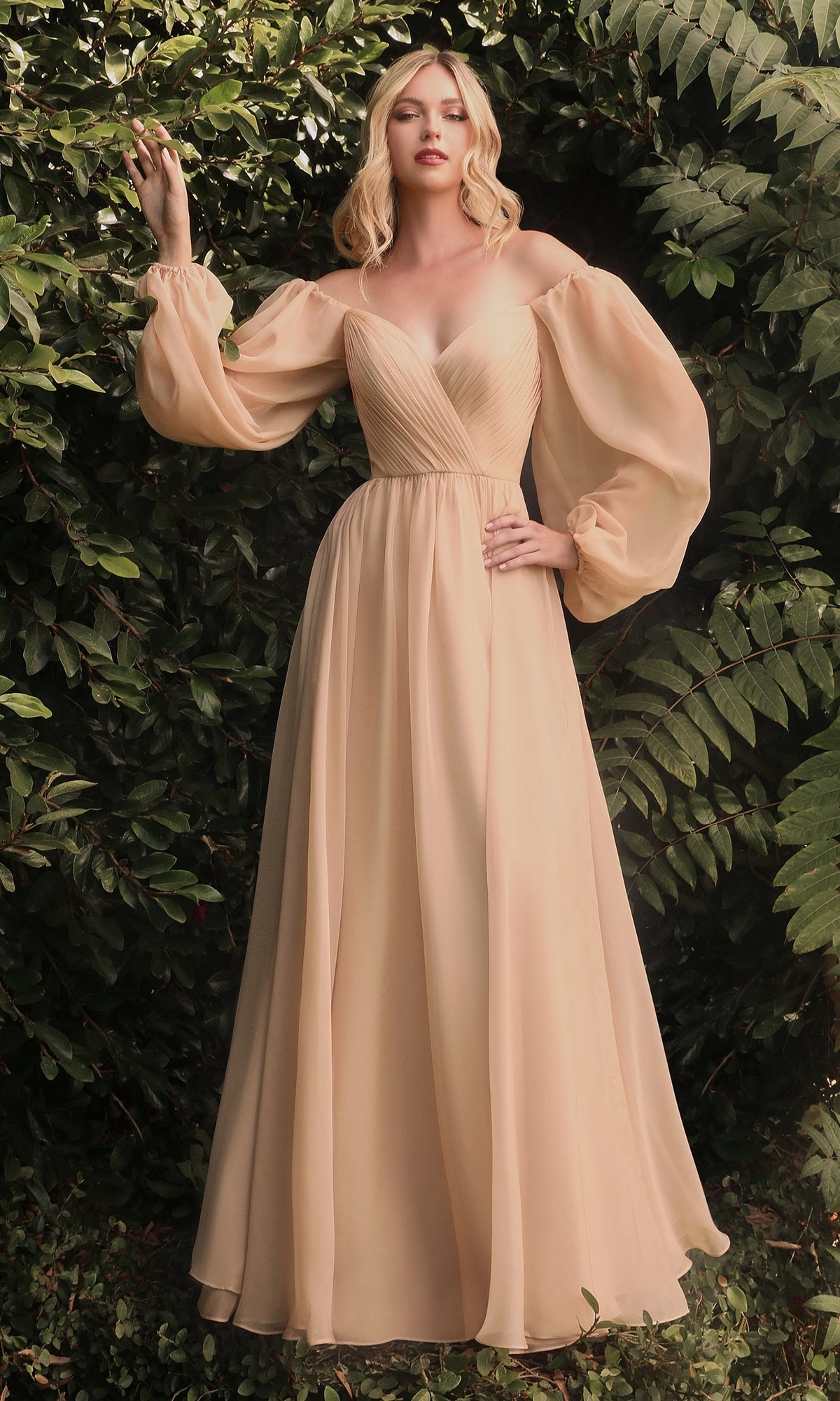 A woman stands outdoors before green foliage, wearing the Ladivine Long Bishop-Sleeve Prom Dress CD243—a light beige, off-the-shoulder gown with voluminous bishop sleeves and a fitted V-neck bodice.