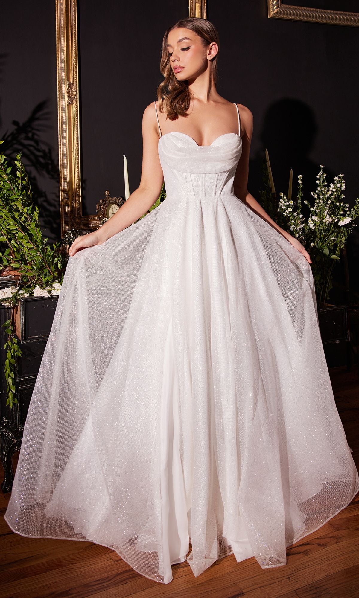 A woman stands indoors wearing the Long White Glitter Sweetheart Prom Dress CD253W, holding out the sides of its sparkling tulle skirt.