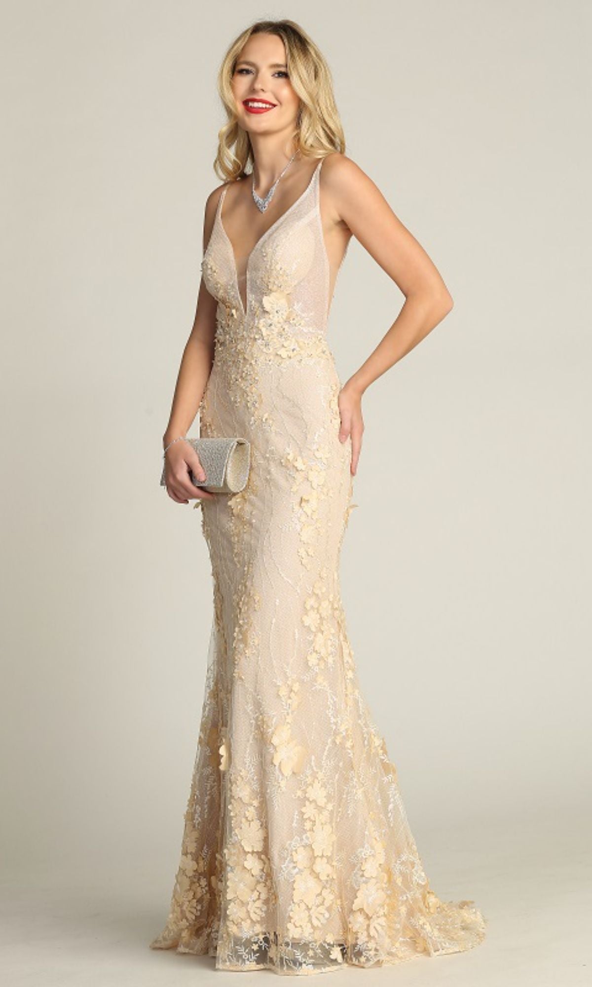 A woman wearing the Chicas CHF3058 Floral-Lace Long Prom Dress holds a silver clutch and stands against a plain background.