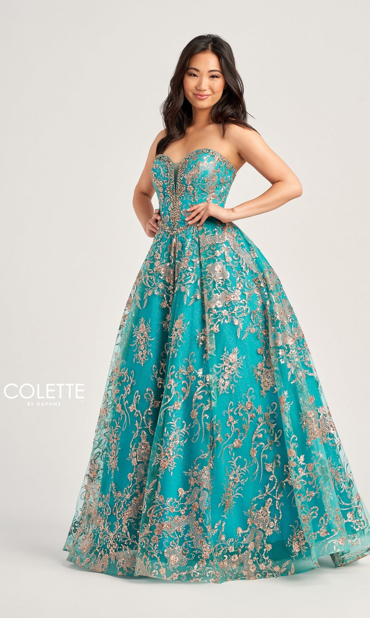 A woman stands against a plain background wearing the Colette Strapless Long Prom Ball Gown CL5101 in teal, featuring gold and silver floral embroidery. The text