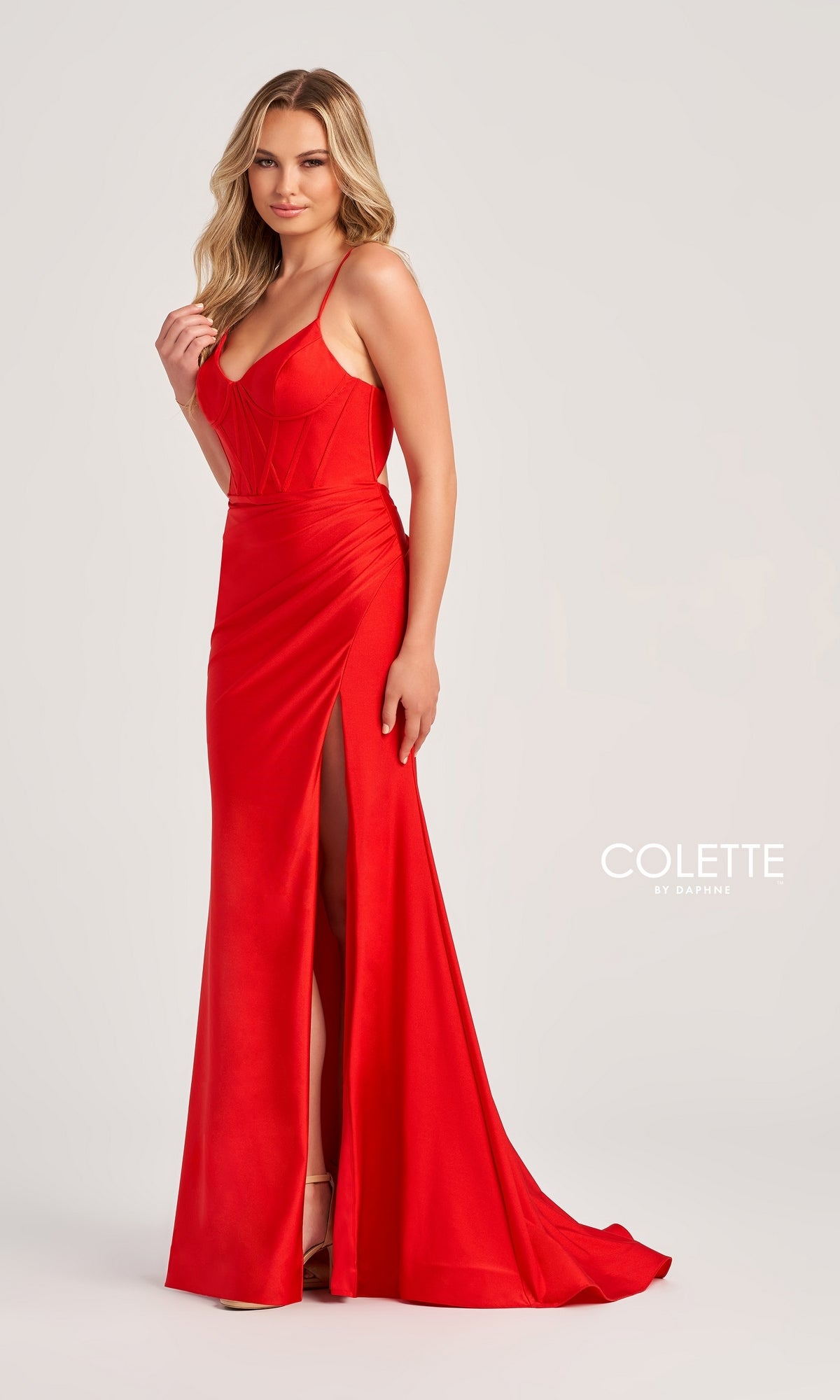 A woman models the Corset-Bodice Long Colette Tight Prom Dress CL5111, a fitted red v-neck gown with spaghetti straps and a thigh-high slit, against a plain light background.