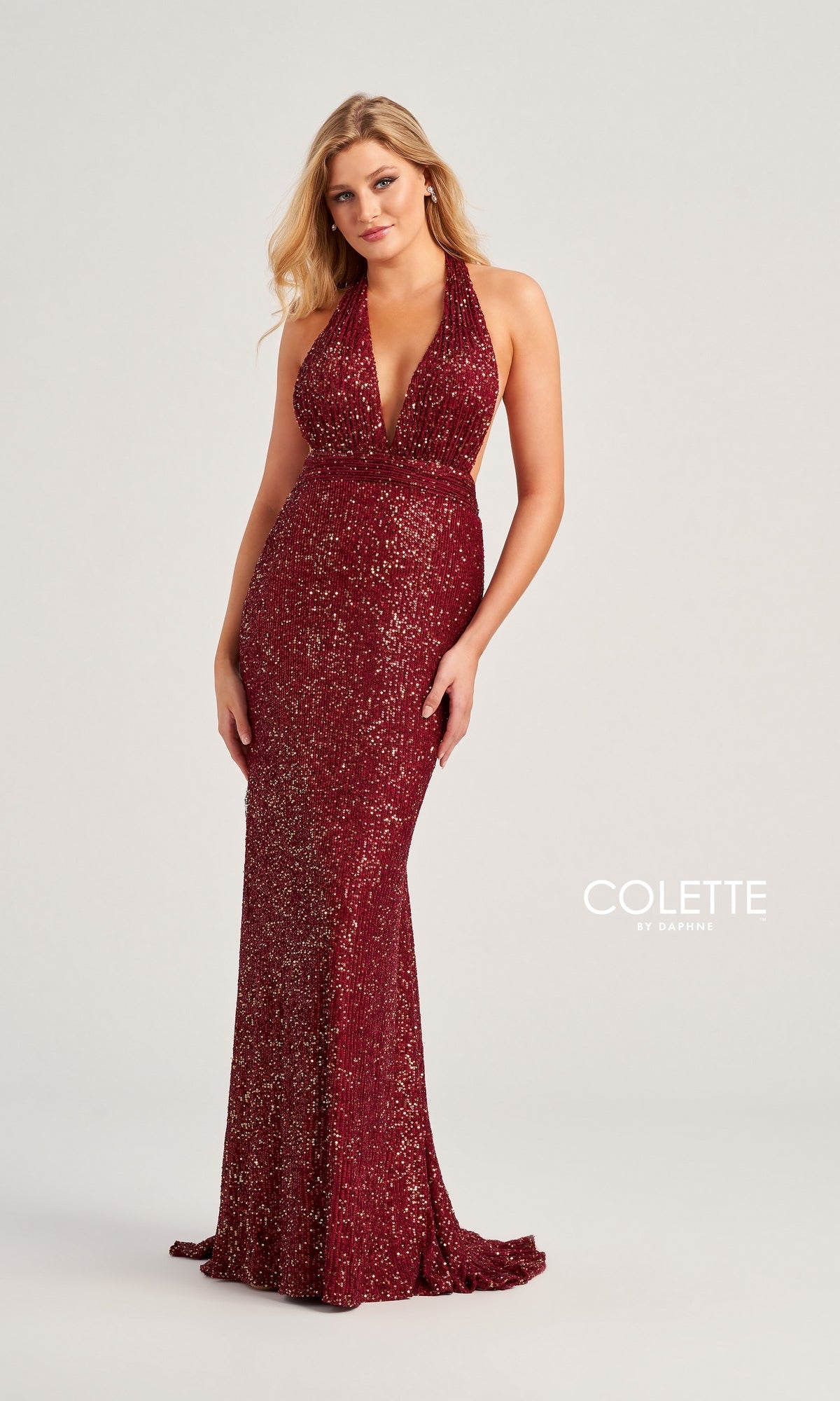 A woman models the Colette Long Sequin Halter Prom Dress CL5115—a sleeveless, fitted, floor-length gown with a deep v-neck and shimmering sequins—posing against a plain light background. The
