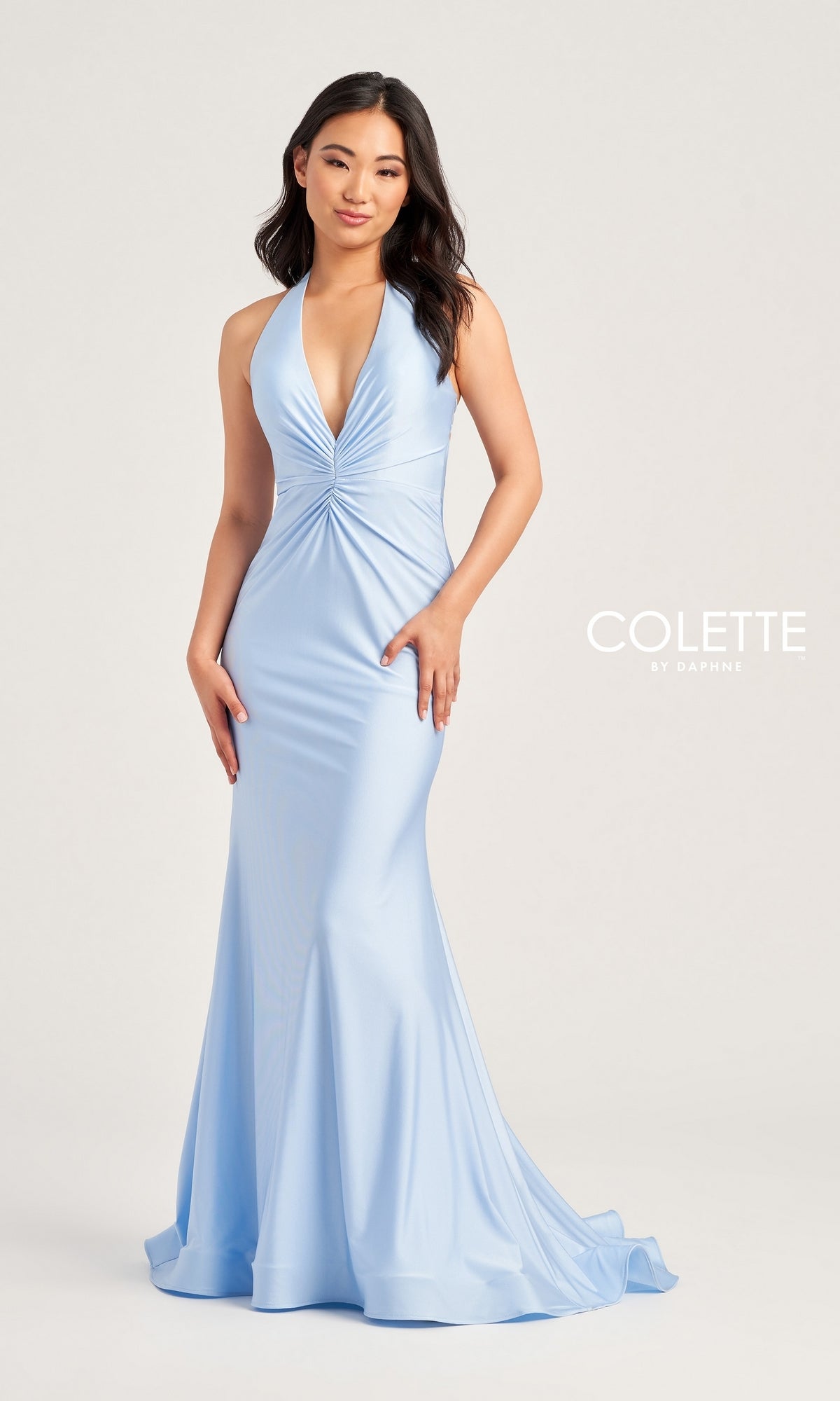 A woman wears the Colette Front-Knot Long Halter Prom Dress CL5199, a light blue, sleeveless, figure-flattering gown with a fitted bodice and flared skirt.