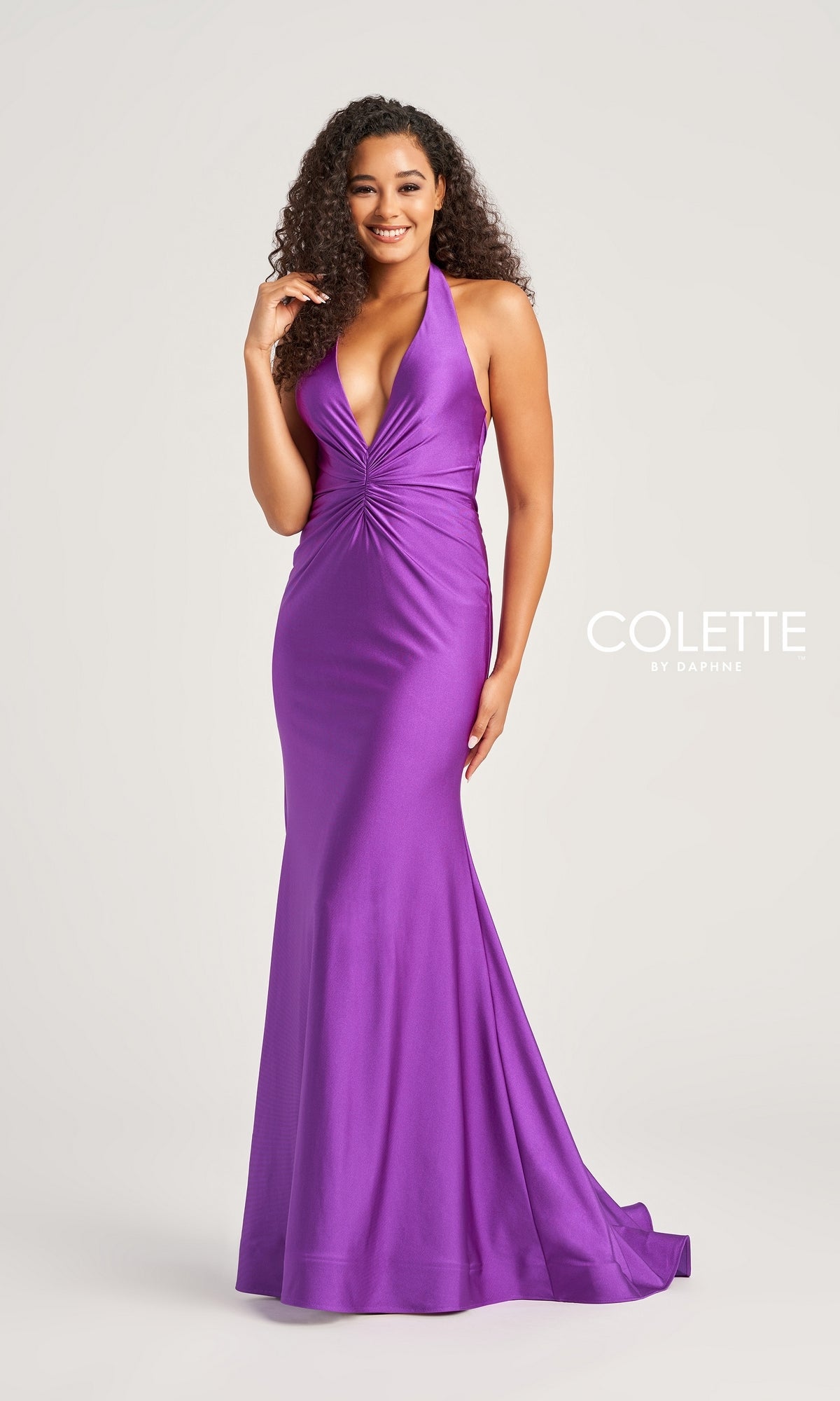 A woman models the Colette Front-Knot Long Halter Prom Dress CL5199, a sleeveless, floor-length stretch spandex jersey gown in purple with a gathered front detail, highlighting its figure-flattering silhouette against a plain backdrop.