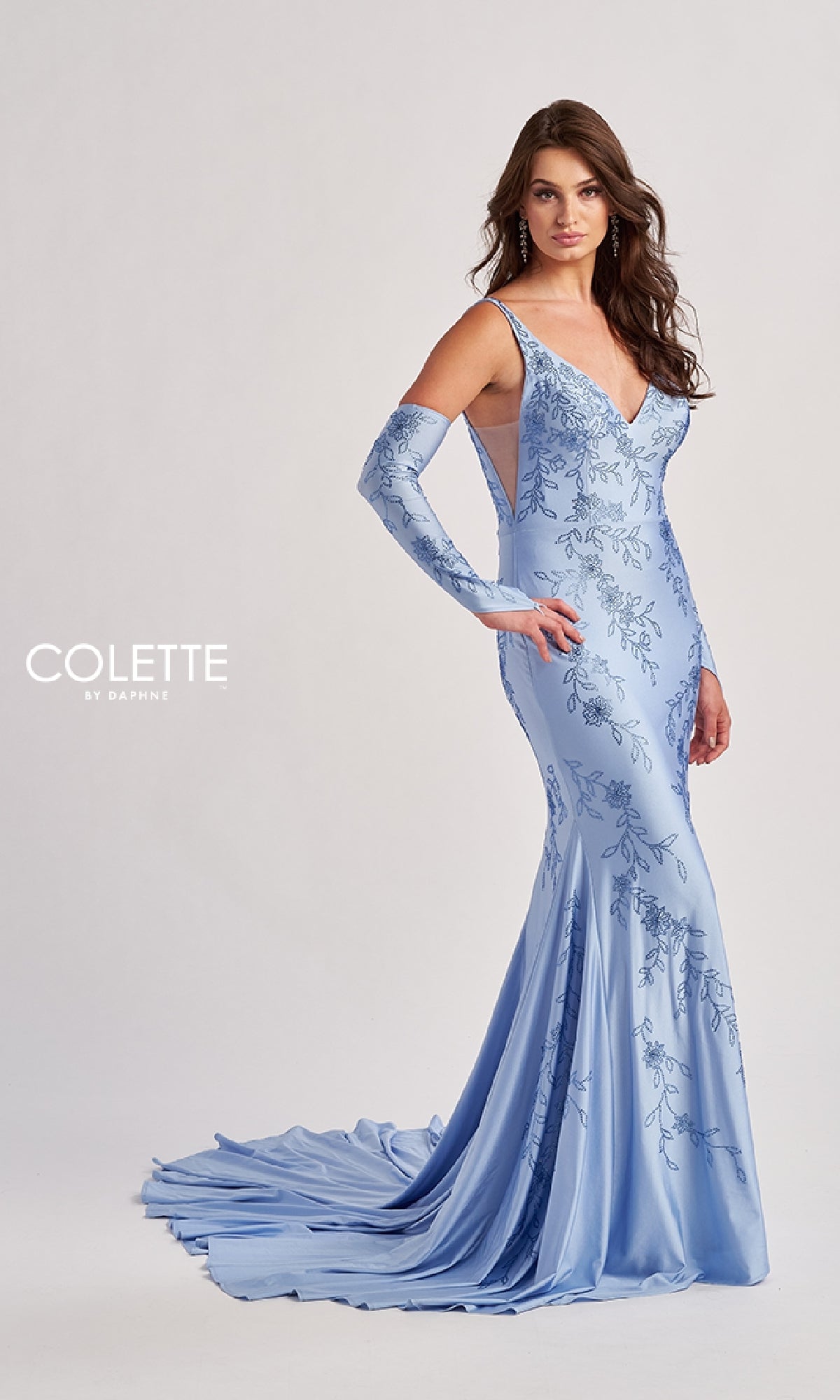 A woman models the Colette CL8475 Long Prom Dress in light blue, a fitted mermaid gown with a train, matching gloves, floral embroidery, sequins, and a deep V-neckline.