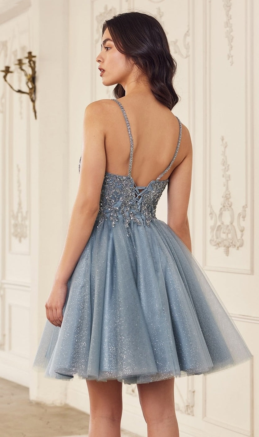 A woman in the Lace-Up Short A-Line Homecoming dress CY022, featuring a light blue color, beaded bodice, and lace-up back, stands in an ornate room.