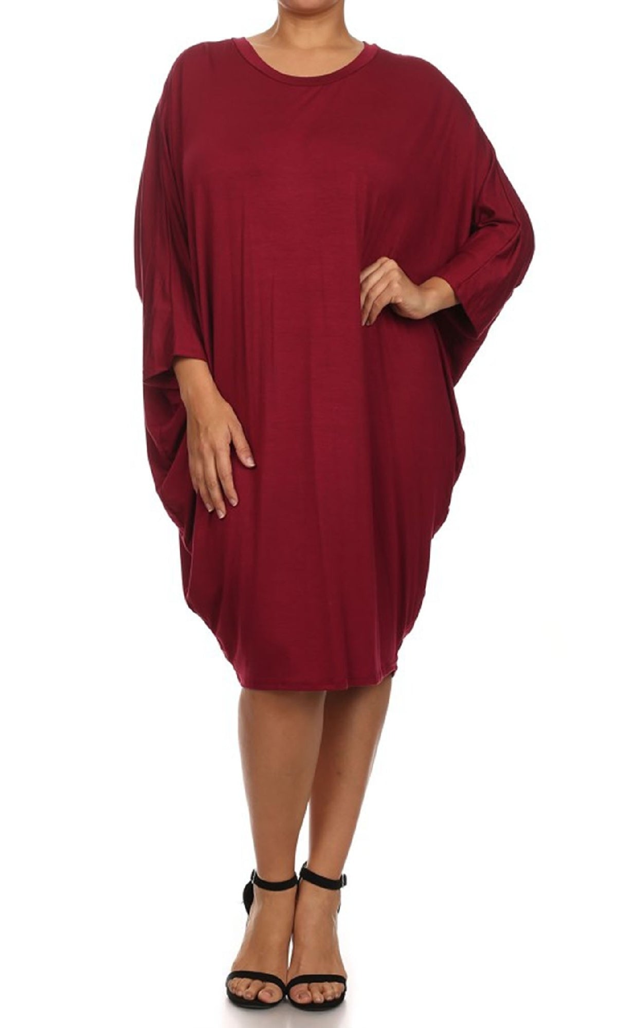 A person wears a burgundy Short Casual Plus Size Dress with dolman sleeves, knee-length and loose-fitting, paired with black ankle-strap sandals, standing against a white background.