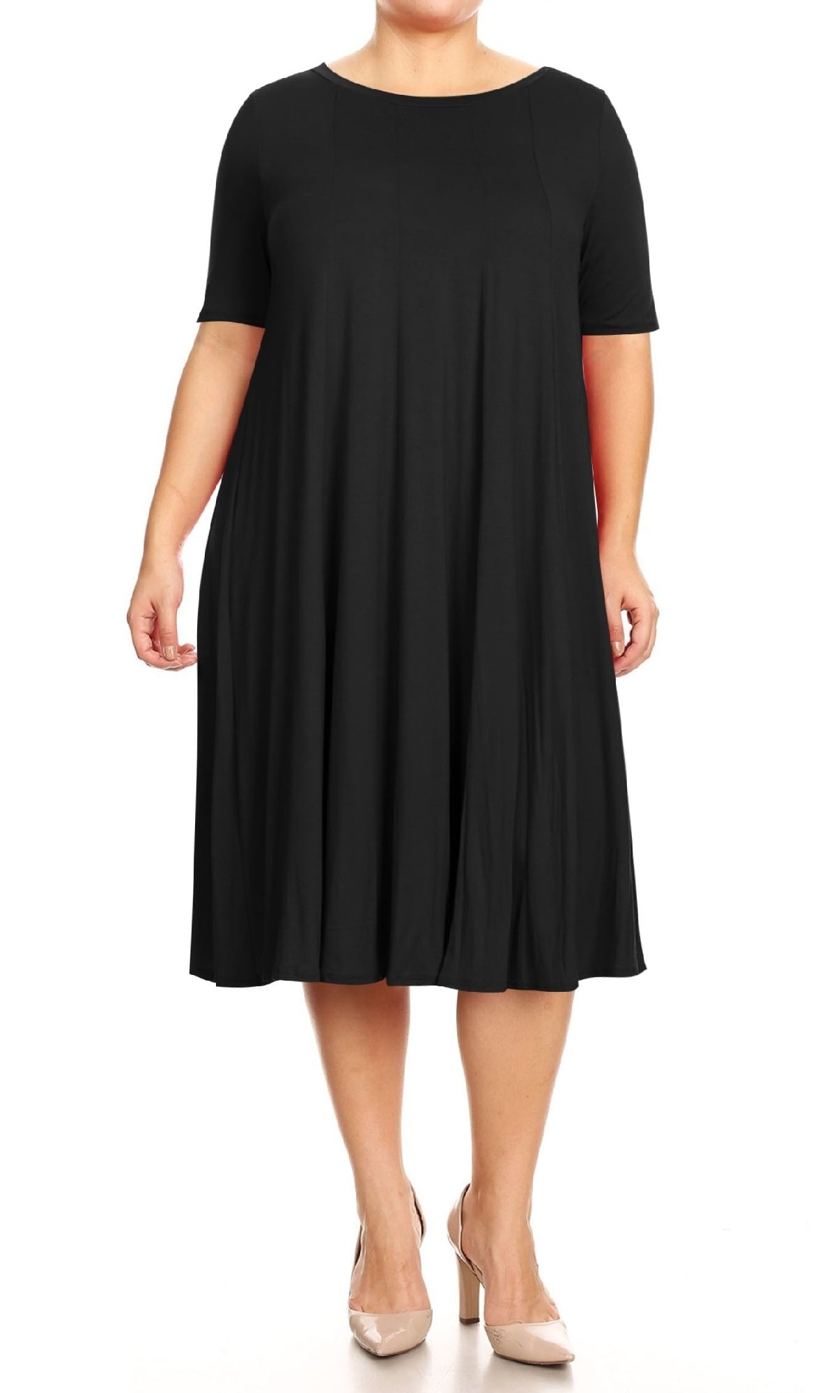 A person models the Plus-Size Jersey Knit Oversized A-Line Casual Dress in black, featuring a loose knee-length fit and short sleeves, paired with nude heels against a white background.