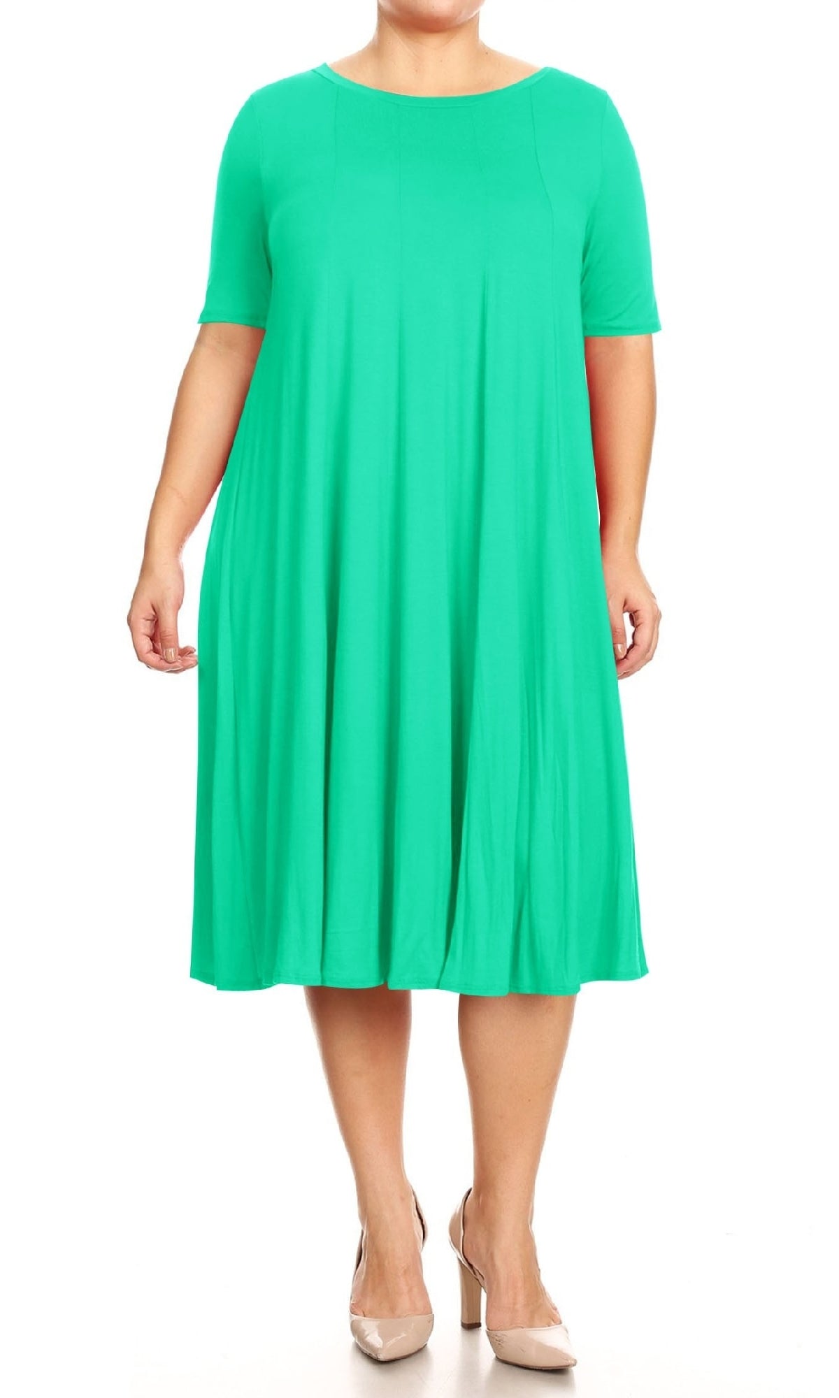 A person models the Plus-Size Jersey Knit Oversized A-Line Casual Dress, a loose-fitting, knee-length, short-sleeved green dress, paired with beige heels against a white background.