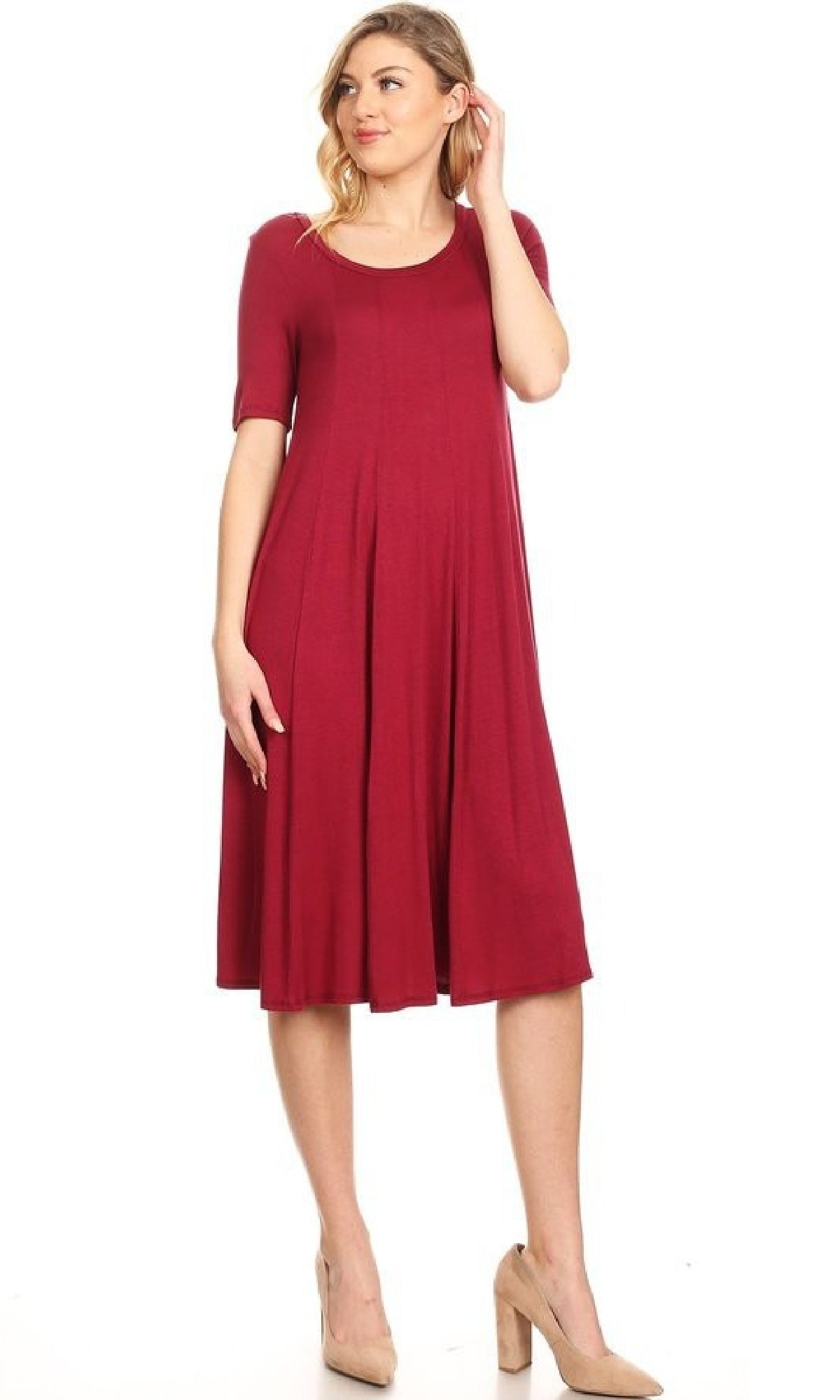 A woman stands in a knee-length, short-sleeve, dark red Short Sleeve Casual Oversized Jersey Knit Dress with a flared skirt and beige heels against a plain white background.