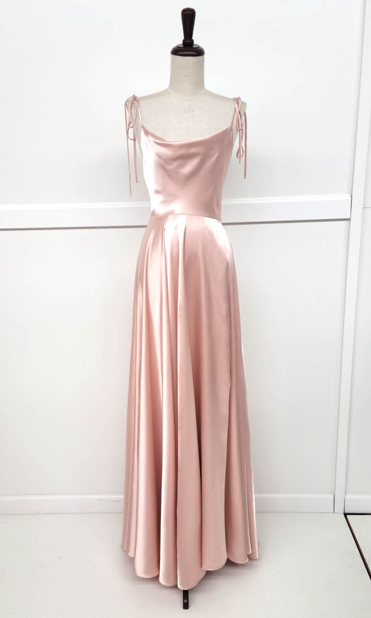 The Chicas DM4018 Shoulder-Tie Long A-Line Prom Dress is a blush pink satin evening gown with thin ties, fitted bodice, and flared floor-length skirt—an elegant and affordable option for special occasions.