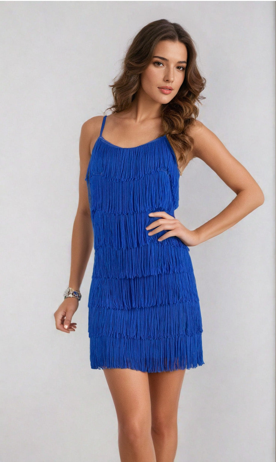 A woman poses confidently with one hand on her hip, wearing the Cheryl Creations 1415 Short Fringe Party Dress—sleeveless, with a blue v-neck and fringe detail—set against a plain light background.