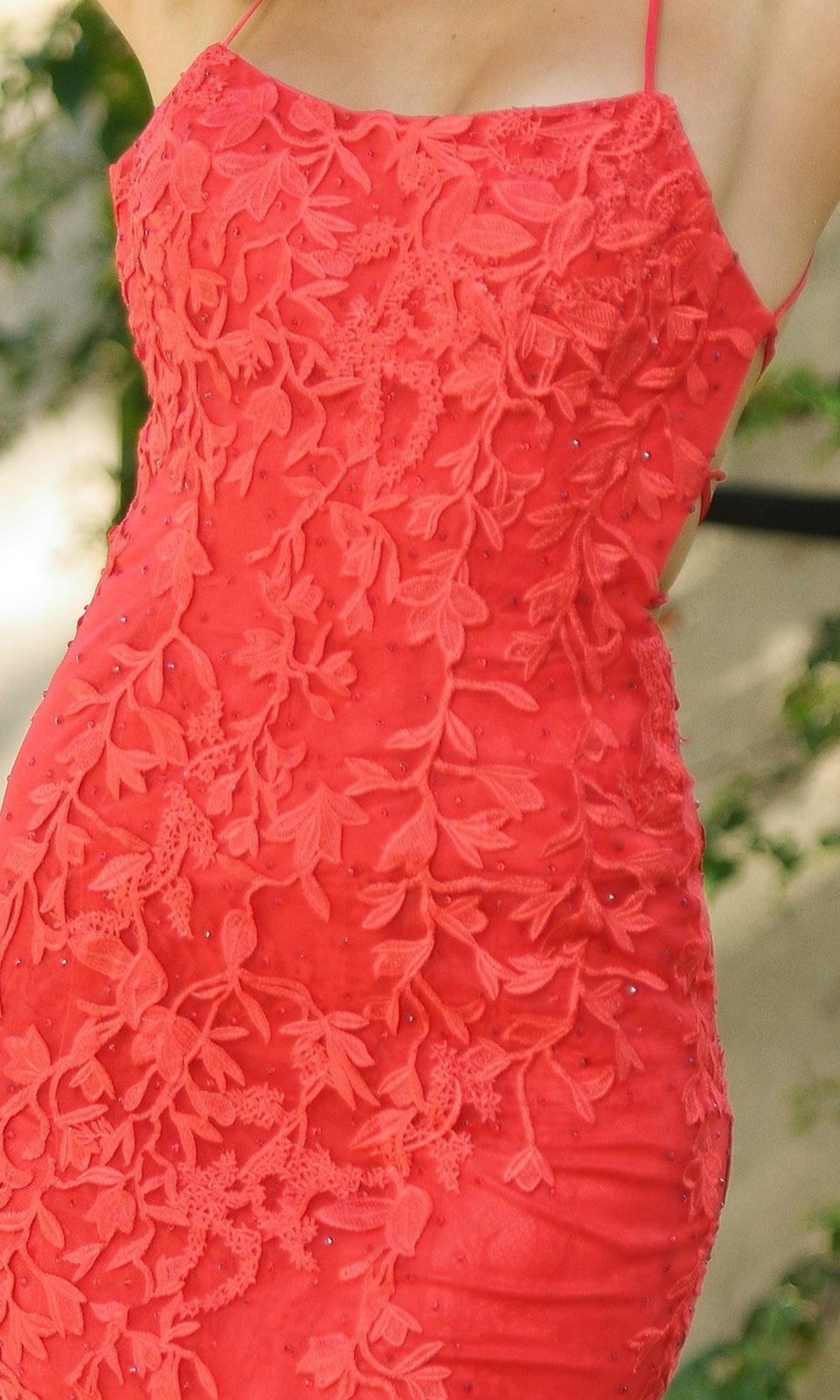 Model wearing the Beaded Lace Long Prom Dress Dutchess, a sleeveless red gown with floral lace details and thin straps, shown from shoulders to mid-thigh.
