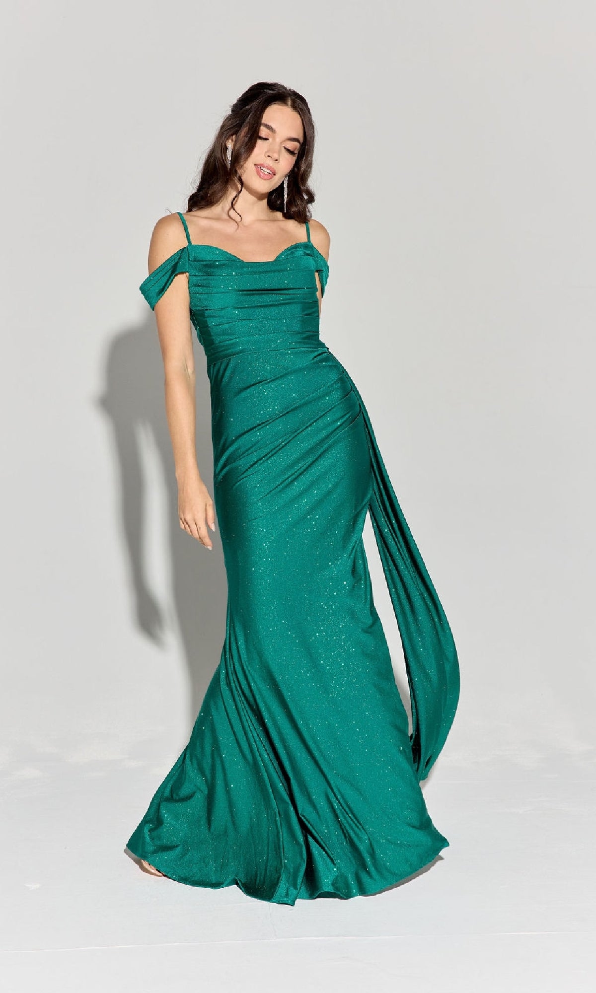 A woman poses against a plain light background wearing the Long Ruched Jersey Prom Dress: Eureka EK107, a green off-the-shoulder evening gown with elegant draped detailing.