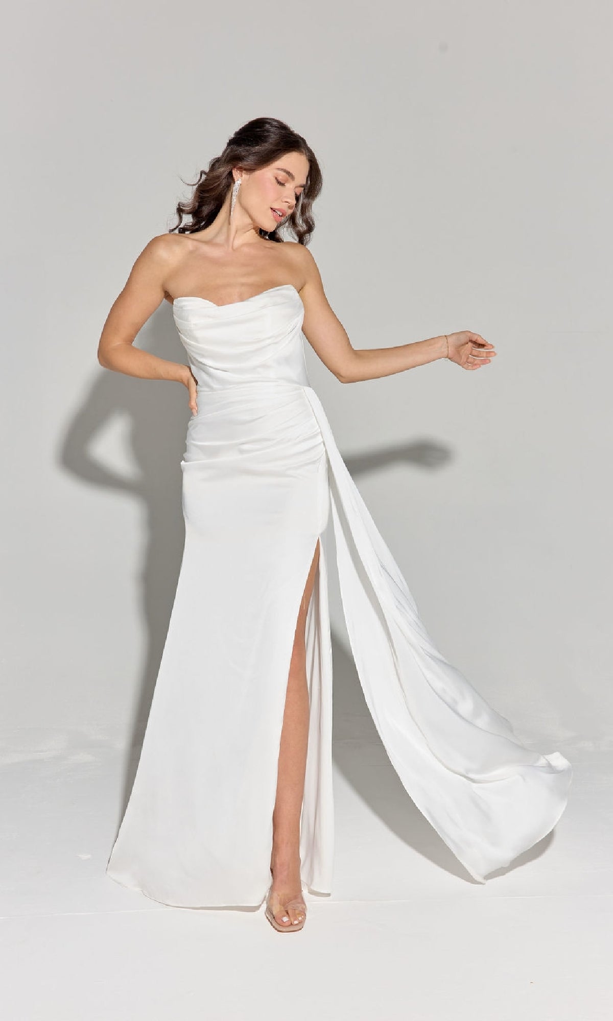 A woman wearing the Strapless Long Satin Prom Dress: Eureka EK118, featuring a thigh-high slit, poses against a plain light background.