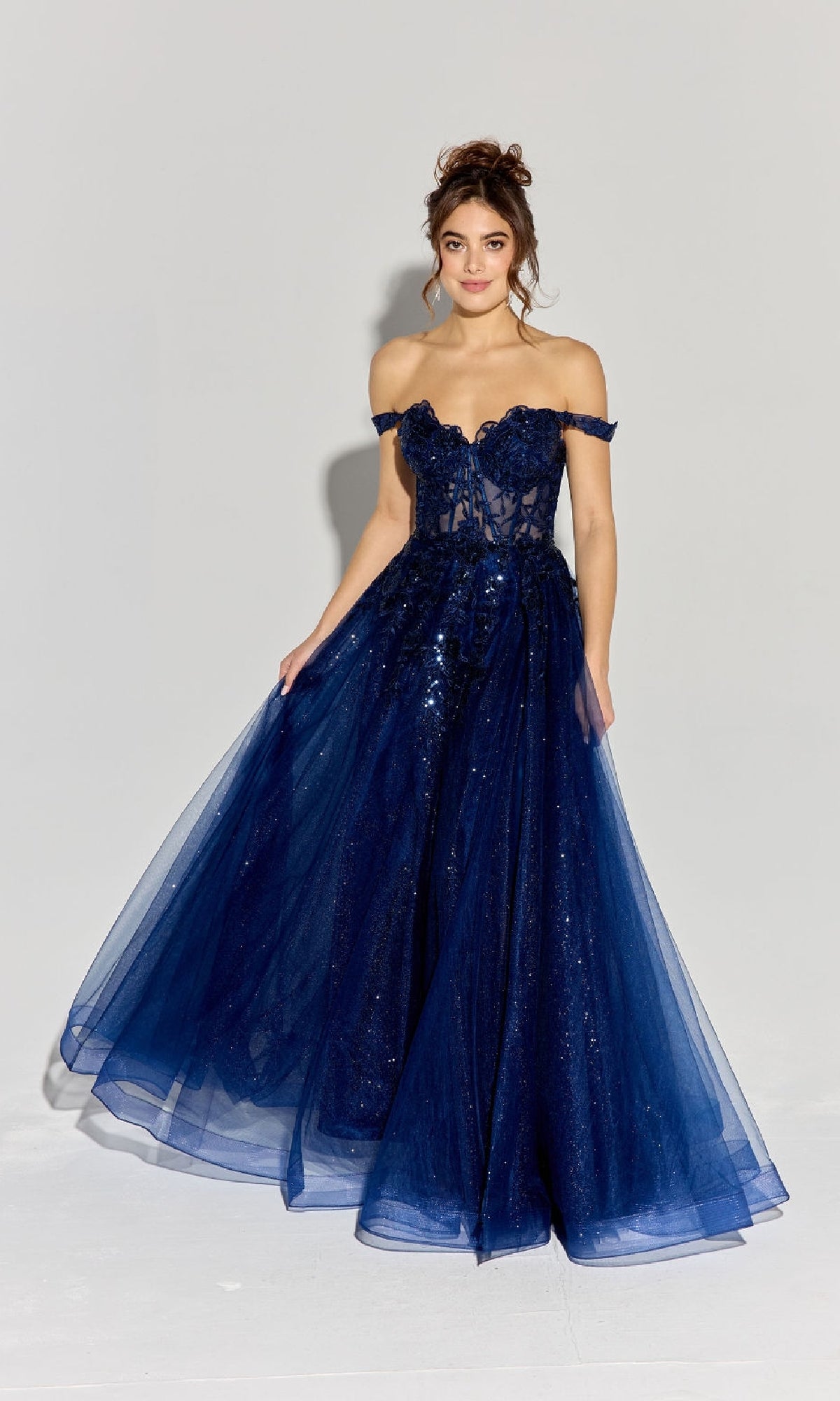A woman models the Off-Shoulder Long Prom Ball Gown: Eureka EK128 in navy blue, featuring a lace tulle skirt and sequin accents, against a plain background.