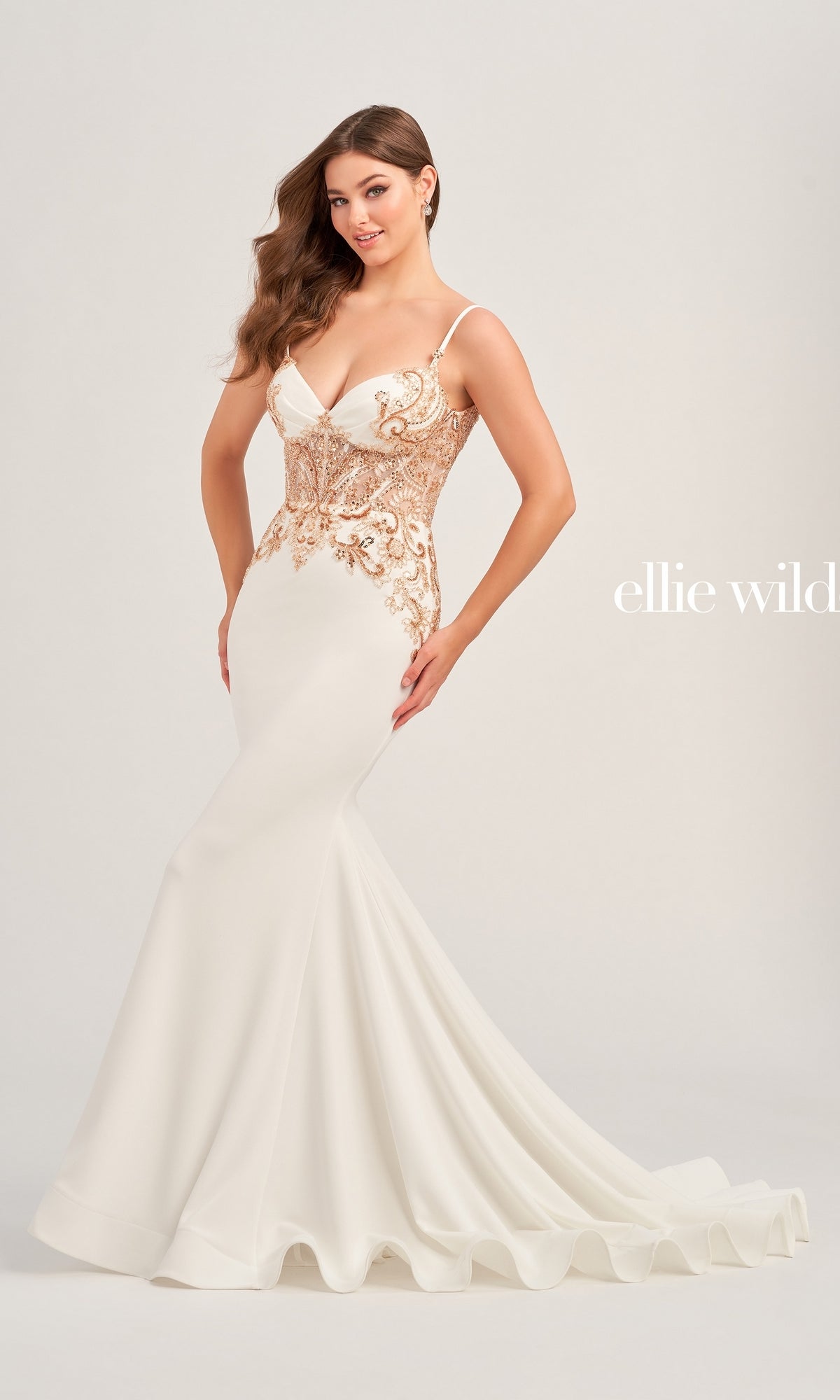 A woman poses against a plain light background in the Ellie Wilde Beaded Long White Formal Dress EW35078, featuring a fitted silhouette and gold beaded applique on the bodice. The brand name
