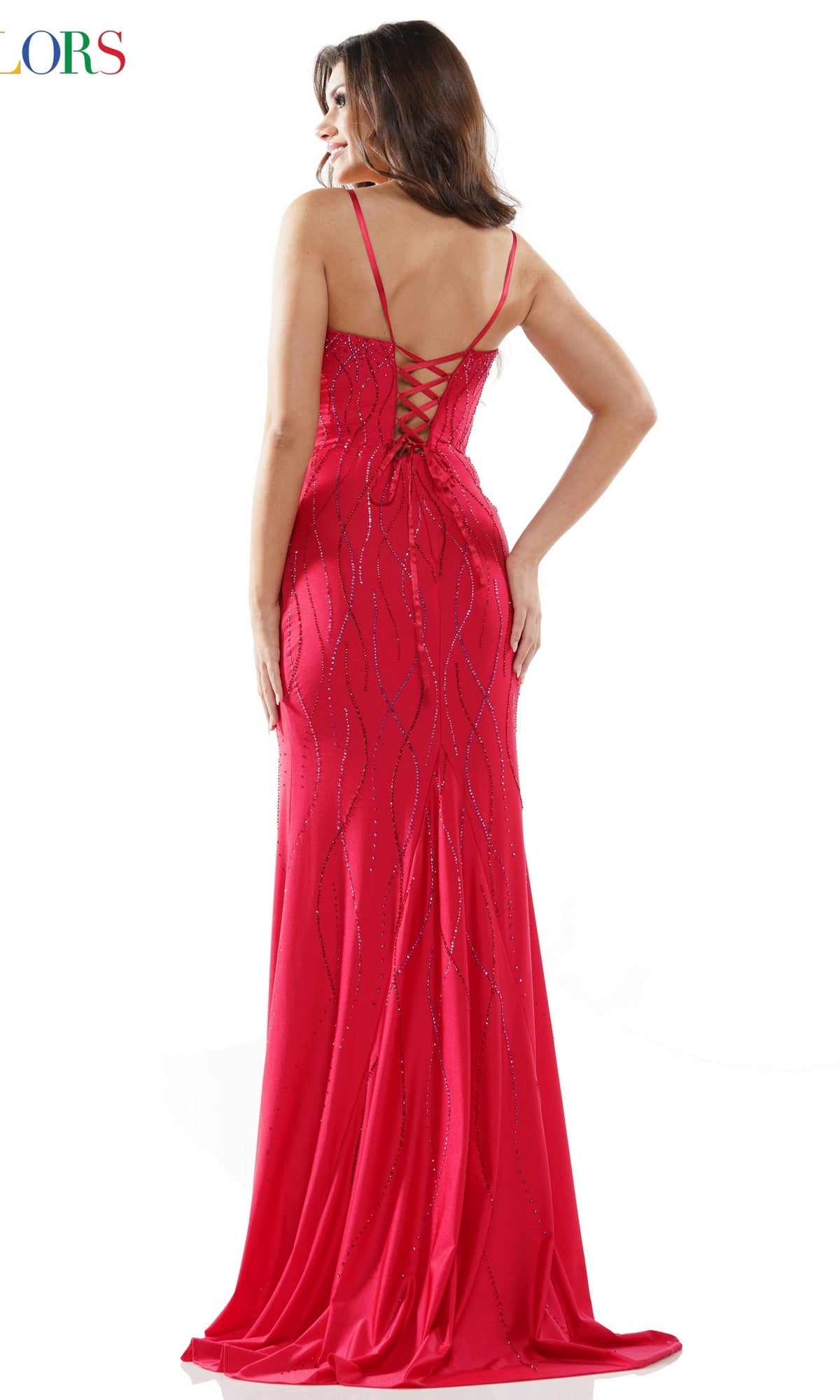 A woman stands facing away from the camera against a white background, wearing the Embellished Lace-Up Long Prom Dress G1052—a floor-length, fitted red gown with thin straps and a lace-up back detail.