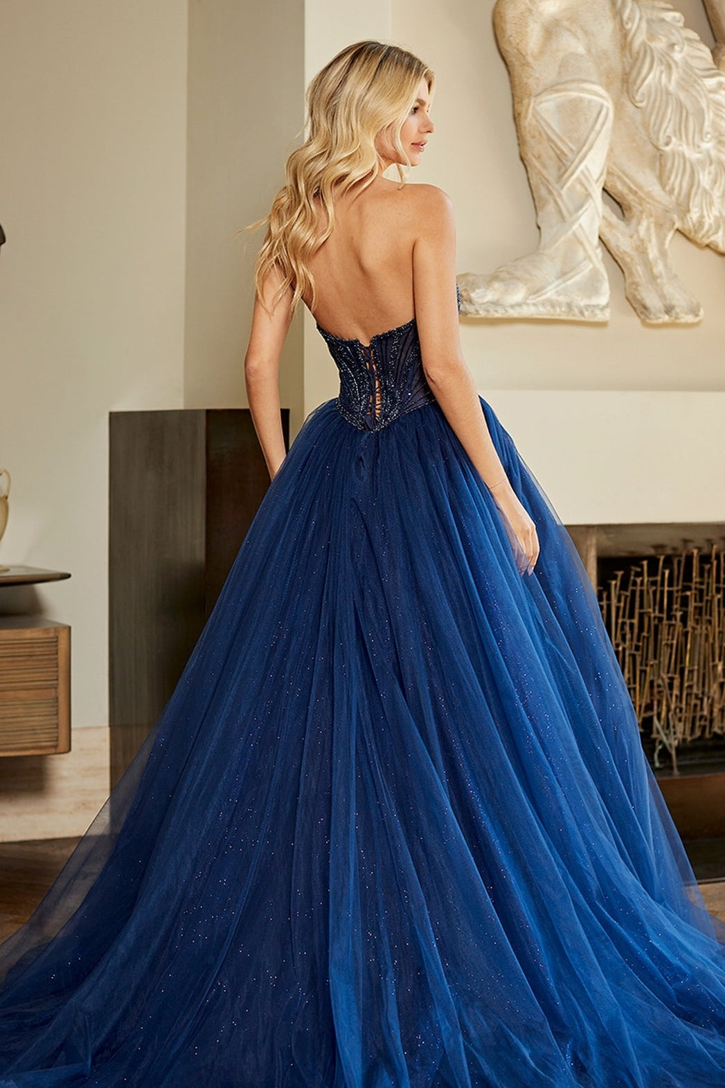 The Amelia Couture JQ1104 strapless prom ball gown in navy blue features a beaded corset bodice and a full glitter tulle skirt.