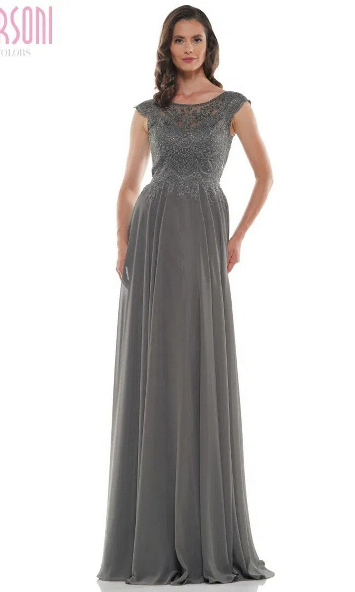 A woman wears the Marsoni M238 long formal dress in charcoal grey, featuring a beaded embroidered bodice, cap sleeves, and a flowing chiffon skirt.