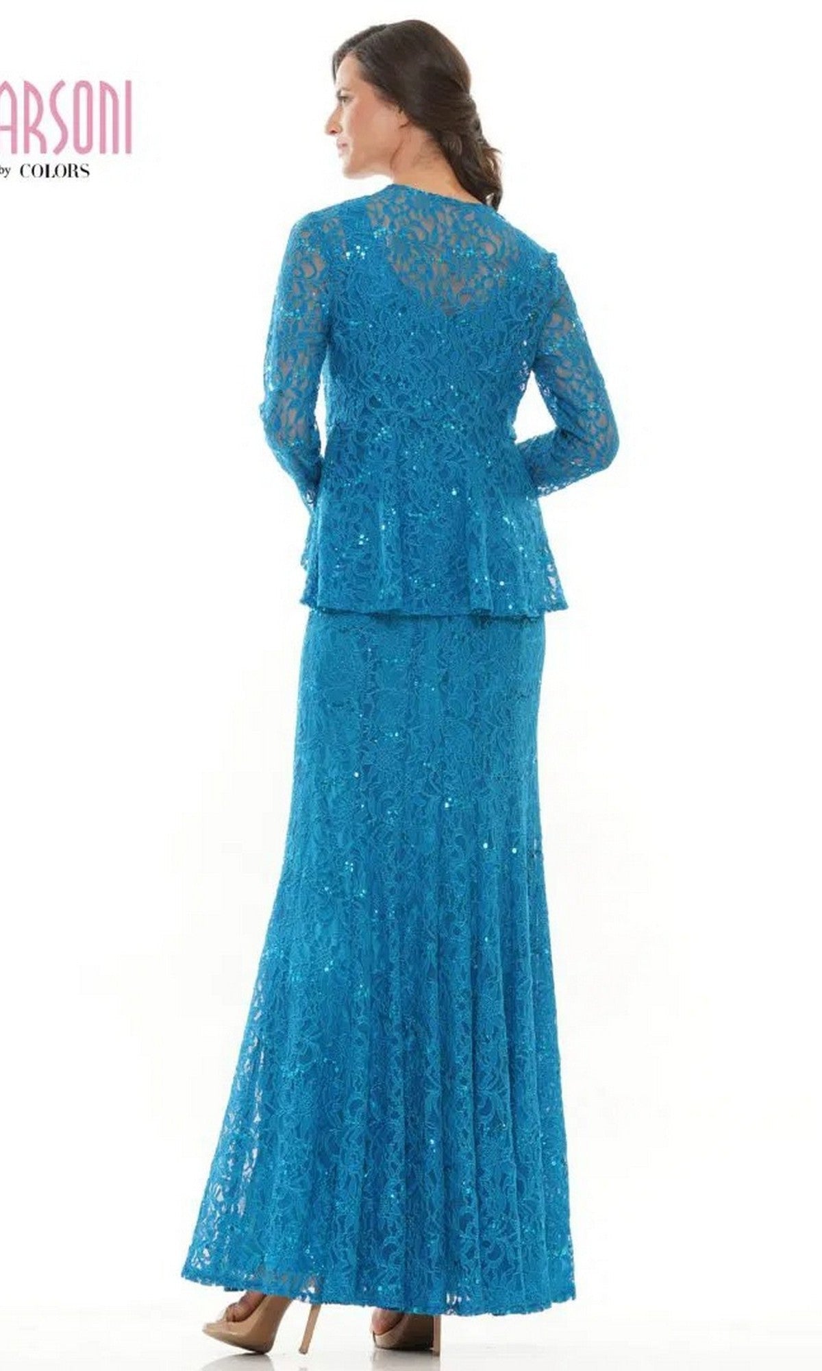 A woman stands facing away, wearing the Marsoni M301—a long-sleeved, floor-length blue lace formal dress featuring a peplum detail and sequin accents.