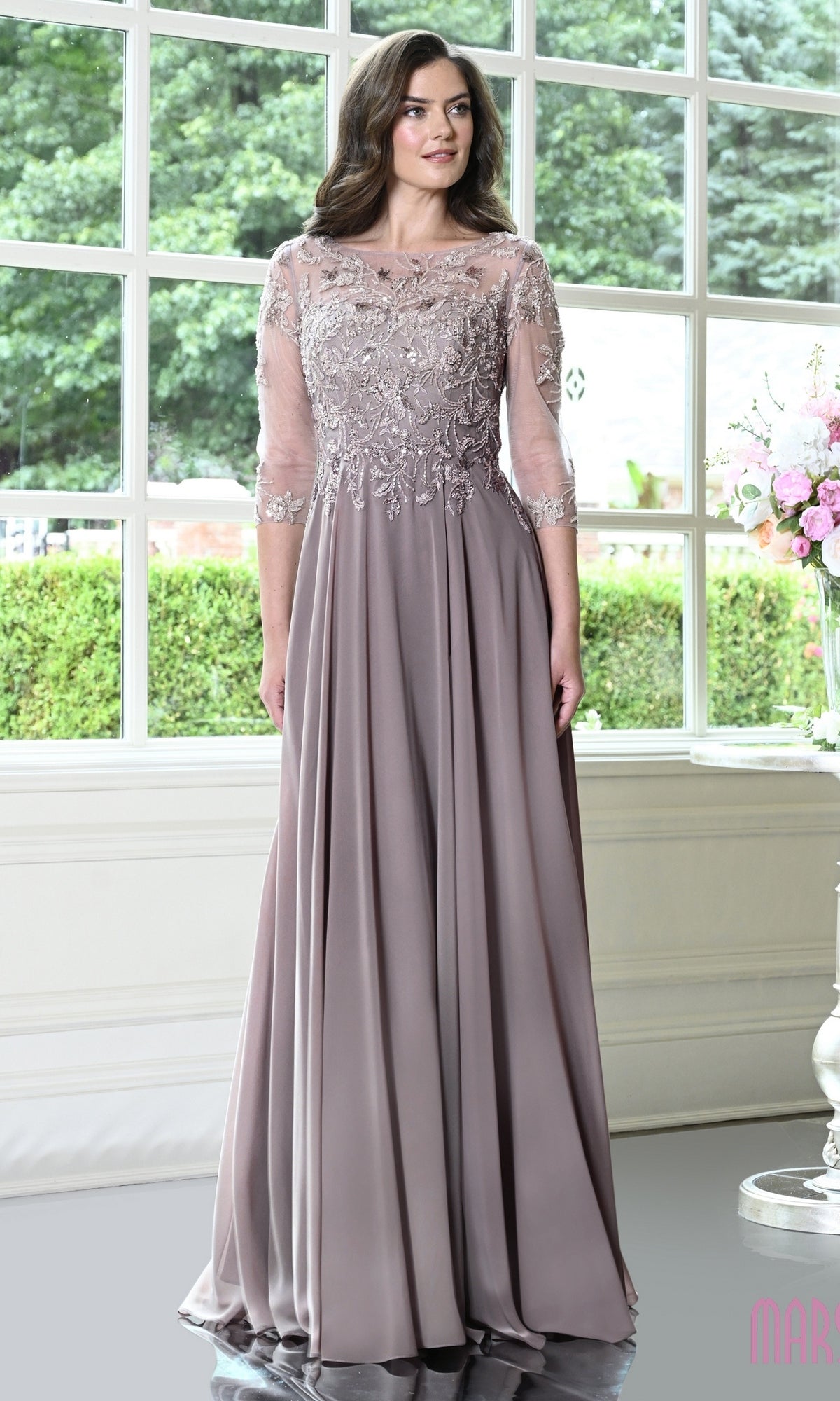 Modest Formal Dress: Marsoni M361 in taupe, a floor-length gown with a sheer, beaded lace bodice, three-quarter sleeves, and a flowing skirt.