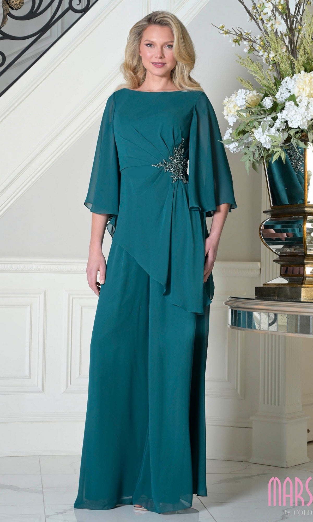 A woman wears the Marsoni MV1411 mother-of-the-bride pantsuit in deep green, offering a stylish and elegant alternative to traditional dresses for any special occasion.