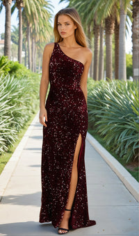 Woman in a burgundy sequin one-shoulder dress standing on a pathway with palm trees in the background.