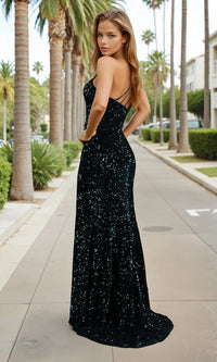 Woman in a green sequin dress standing on a sidewalk with palm trees in the background