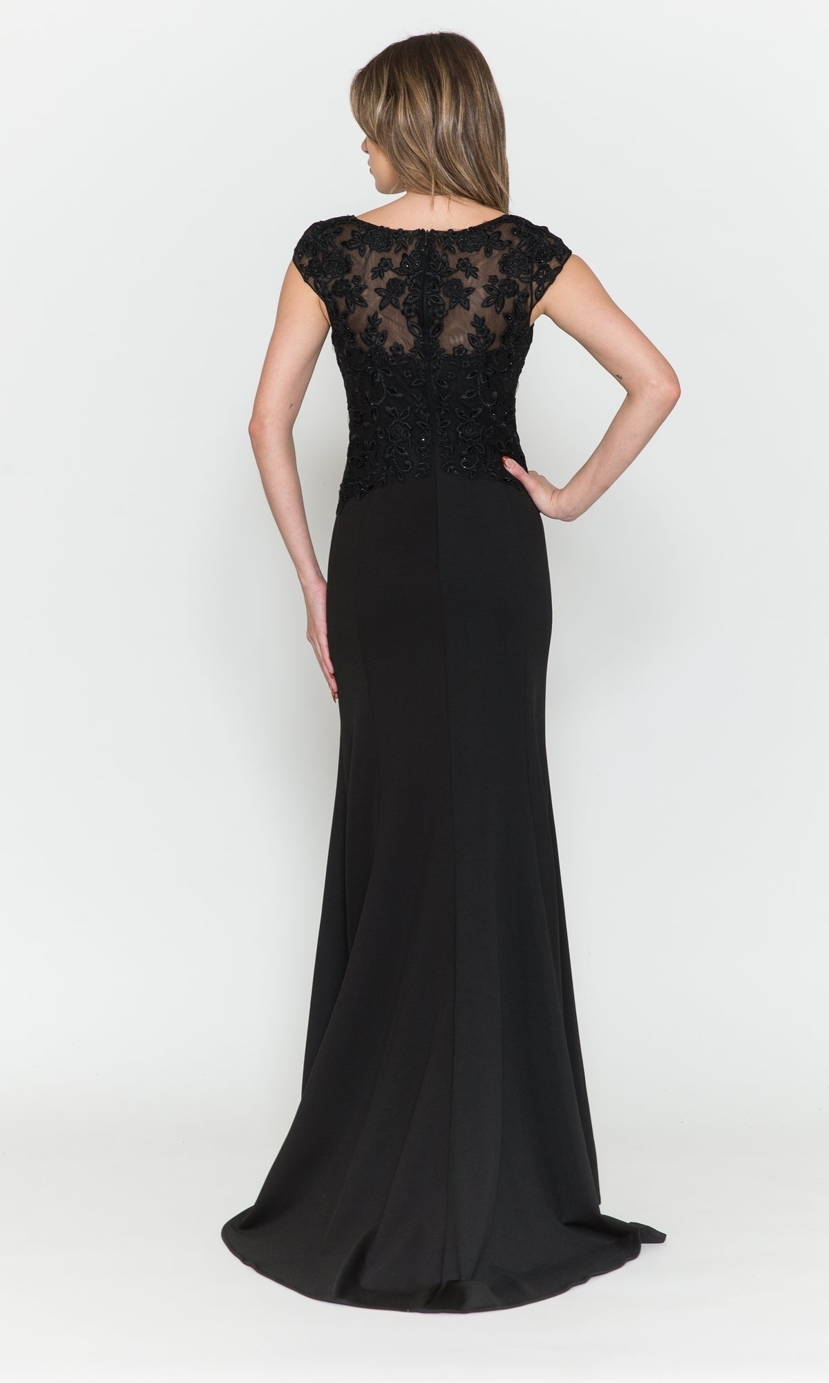 A woman stands with her back to the camera, wearing the Cap-Sleeve Embroidered Jersey Long Prom Dress 8558—a floor-length black gown with sheer lace back—against a plain white background.