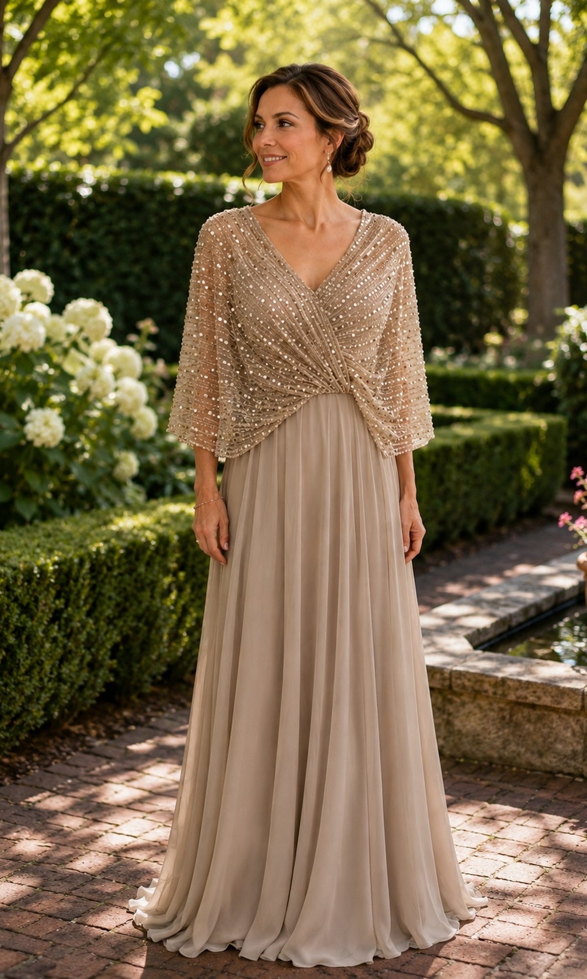 Woman wearing a Rina Di Montella R102 beaded capelet long formal dress in champagne with a floor-length, wrap-style bodice.