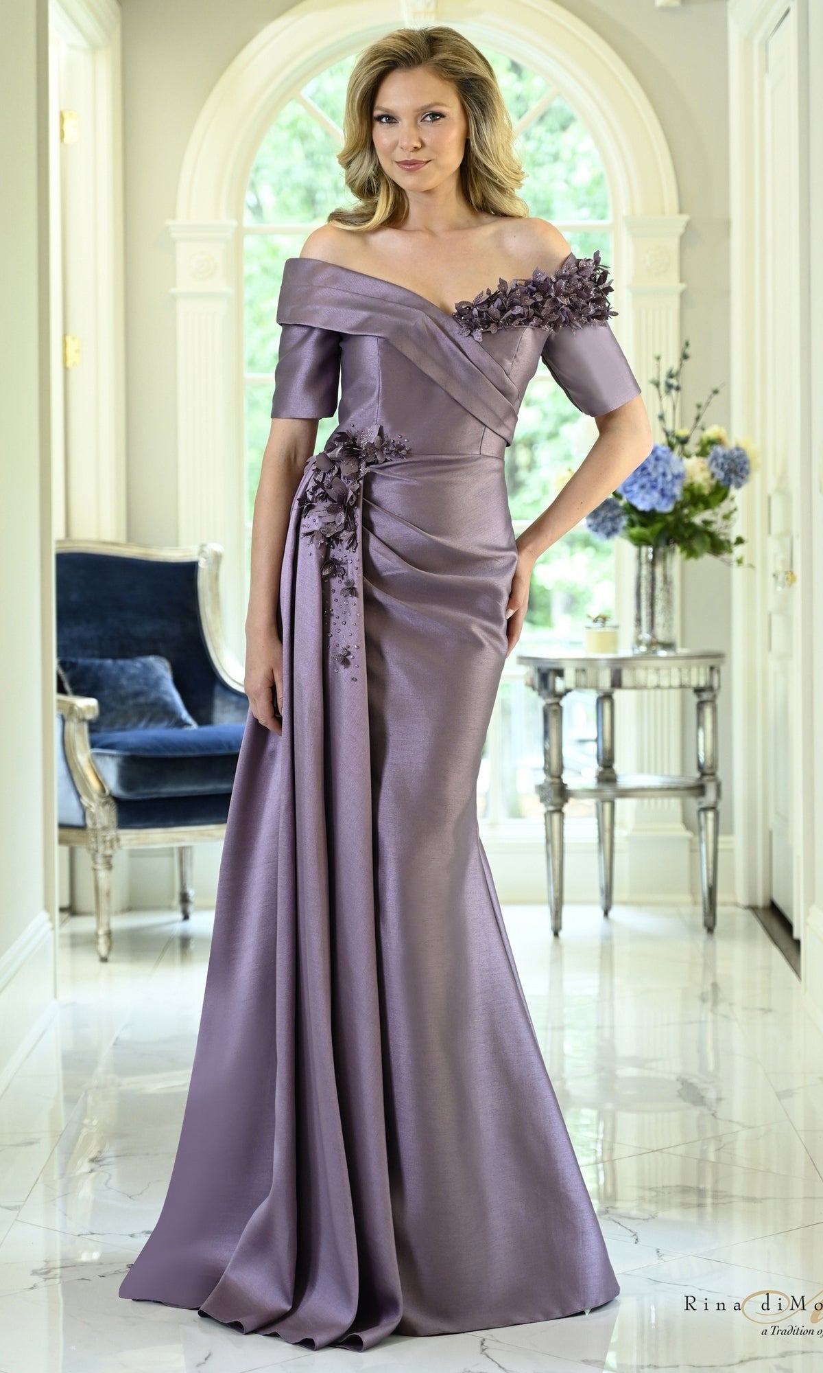 Victorian Lilac Off-the-Shoulder Floral Mermaid Formal Dress: Rina Di Montella RD3611 featuring floral appliqué on the shoulder and hip in a sleek mermaid silhouette.