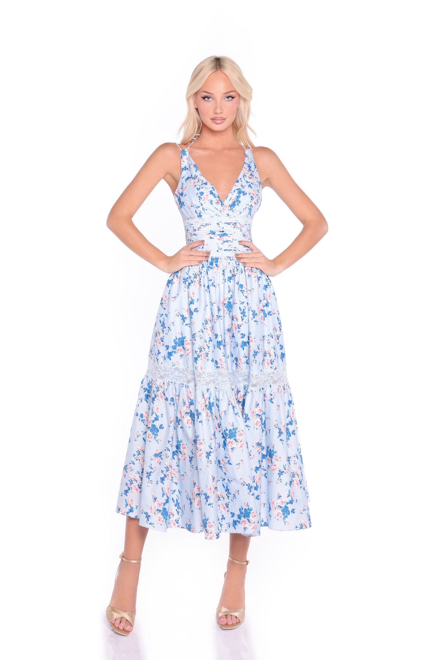 A woman in the Blue Floral Midi Casual Dress: Solene and tan high-heeled sandals stands against a white background.