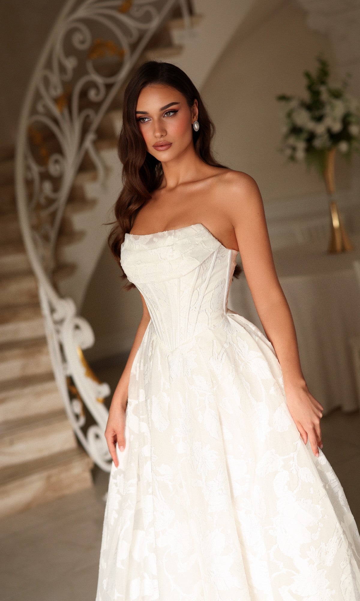 A woman wearing a Tina Holly TW623 long wedding dress, featuring a white organza jacquard strapless corset bodice and an A-line floor-length skirt.